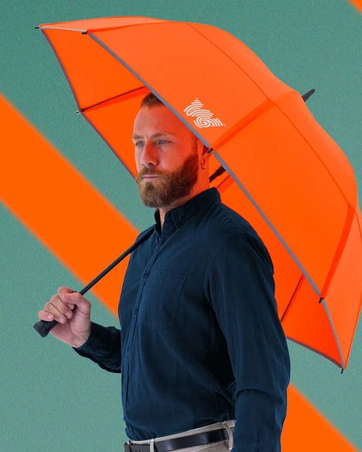 man holding weatherman neon orange umbrella