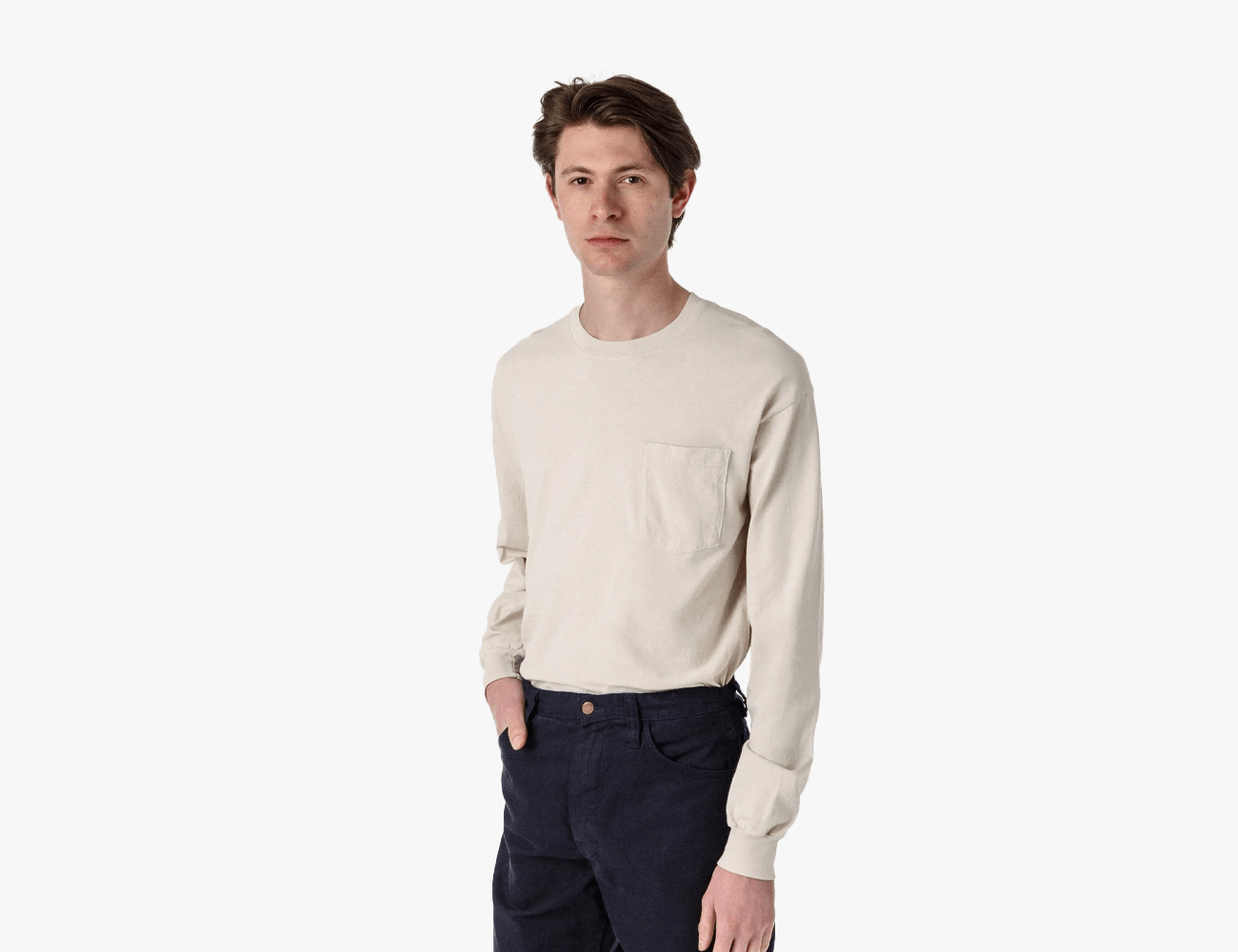 a man wearing an off white long sleeve shirt and black jeans