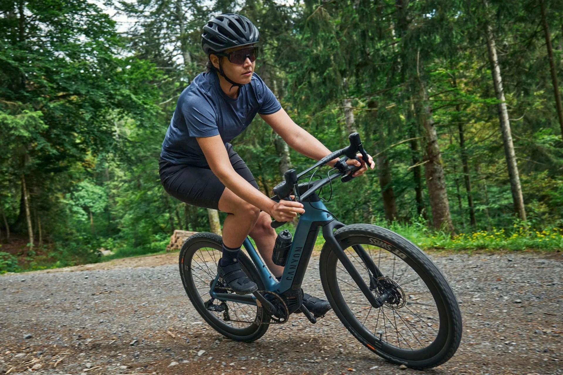 a person riding a bike on a gravel road