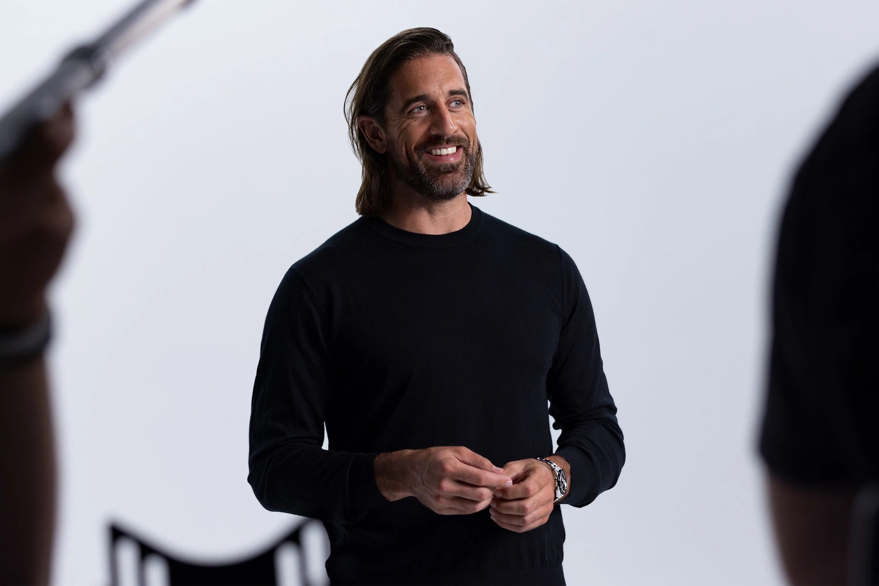 aaron rodgers in a photo studio wearing all black and a zenith watch