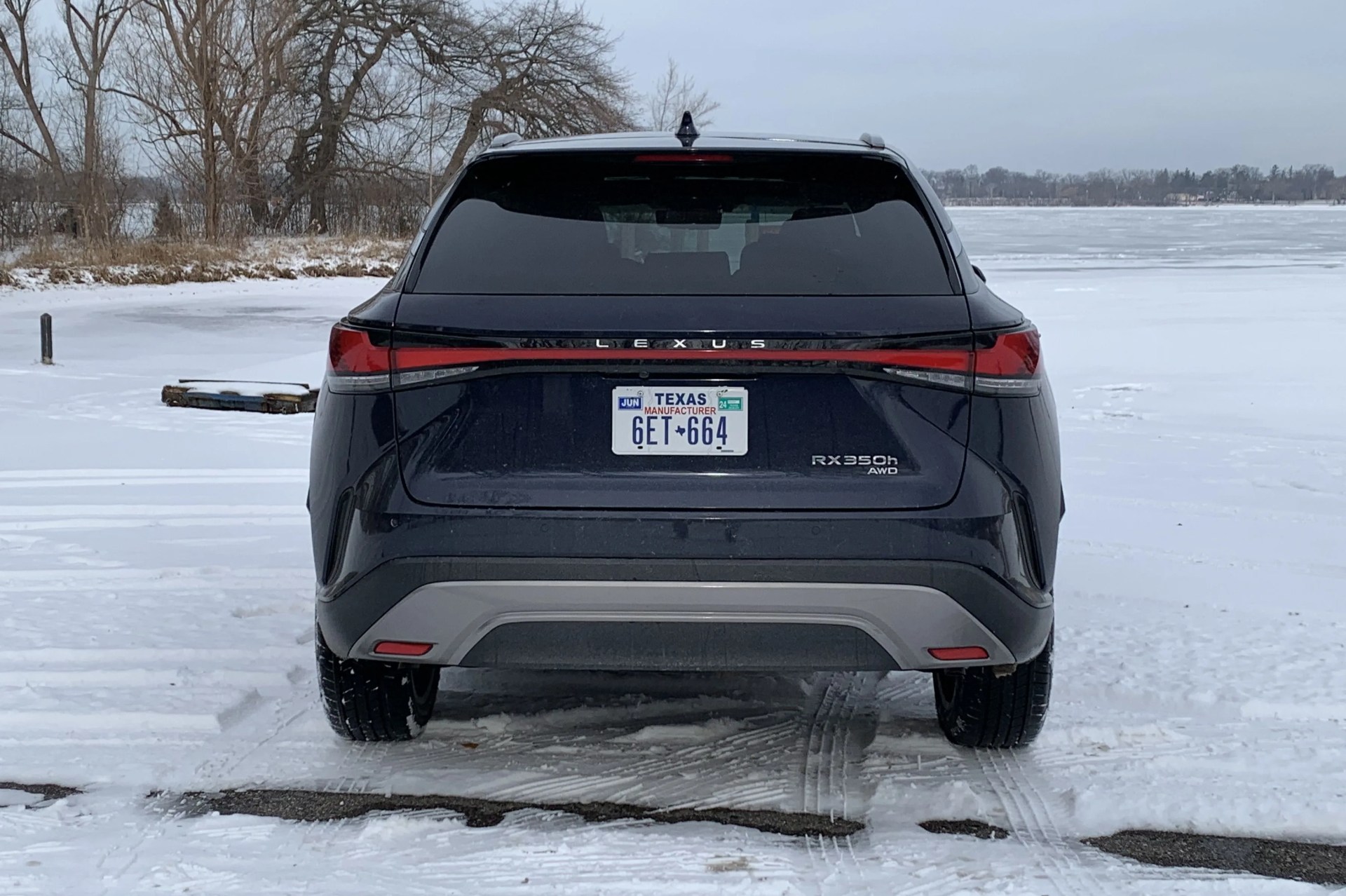lexus rx 350h parked by a snowy lake