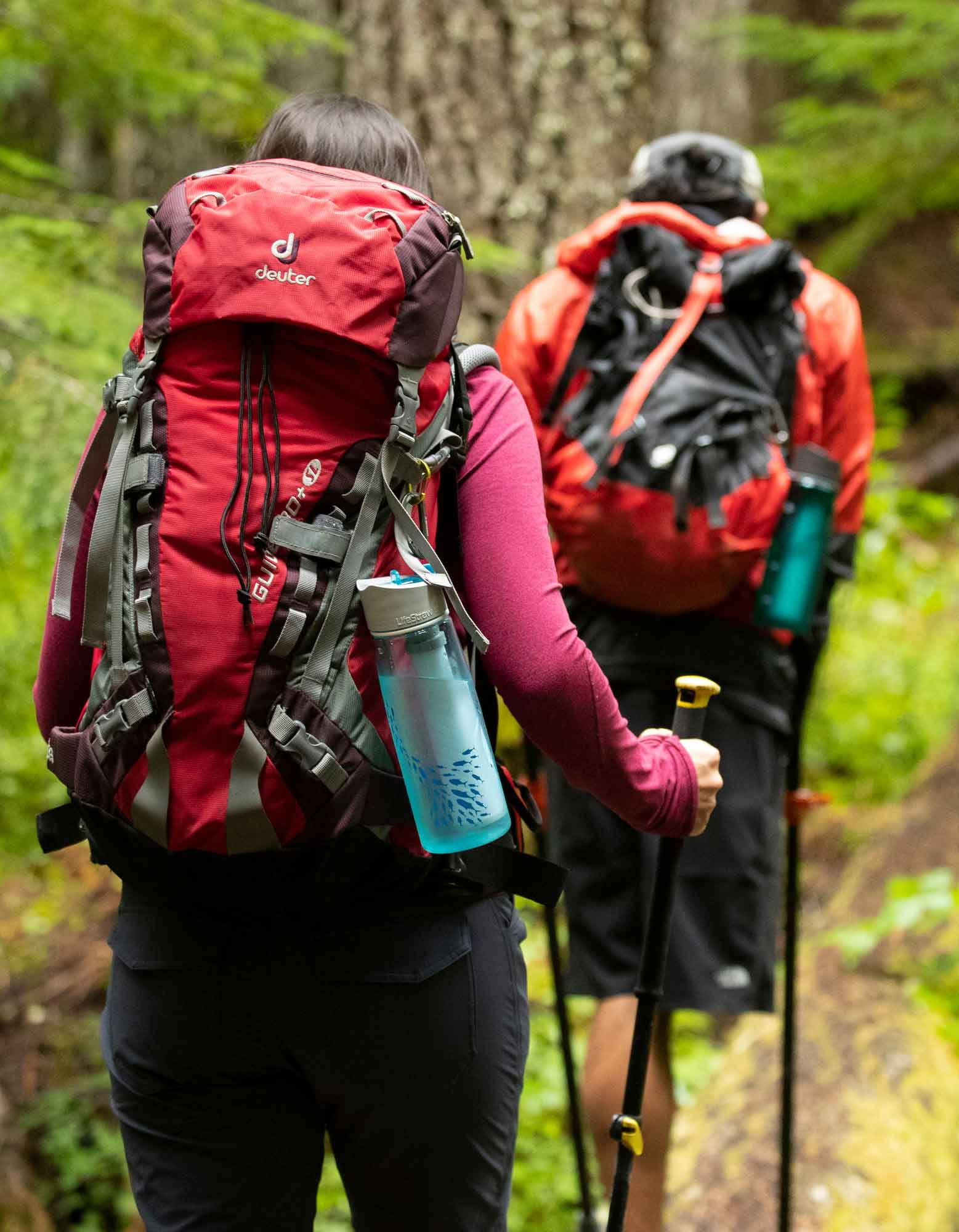 two people hiking with lifestraw water bottles