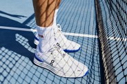 a person wearing white tennis shoes on a tennis court