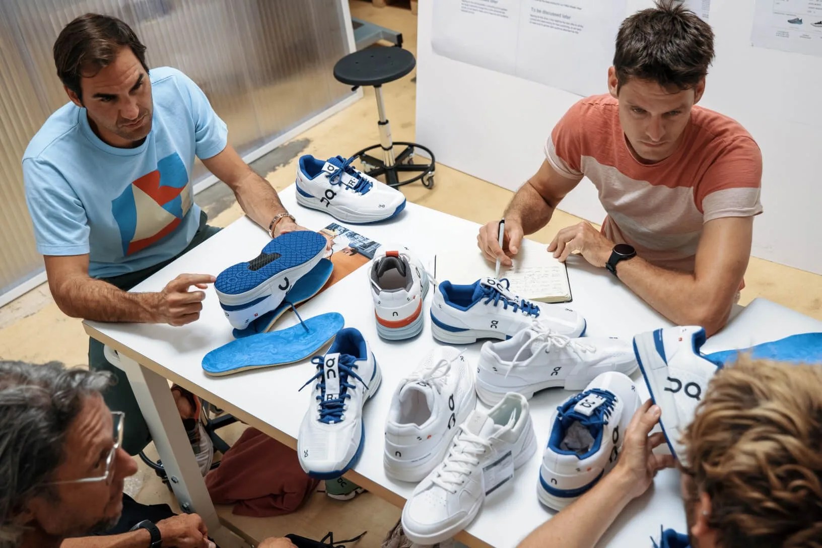 roger federer and a pile of shoe prototypes