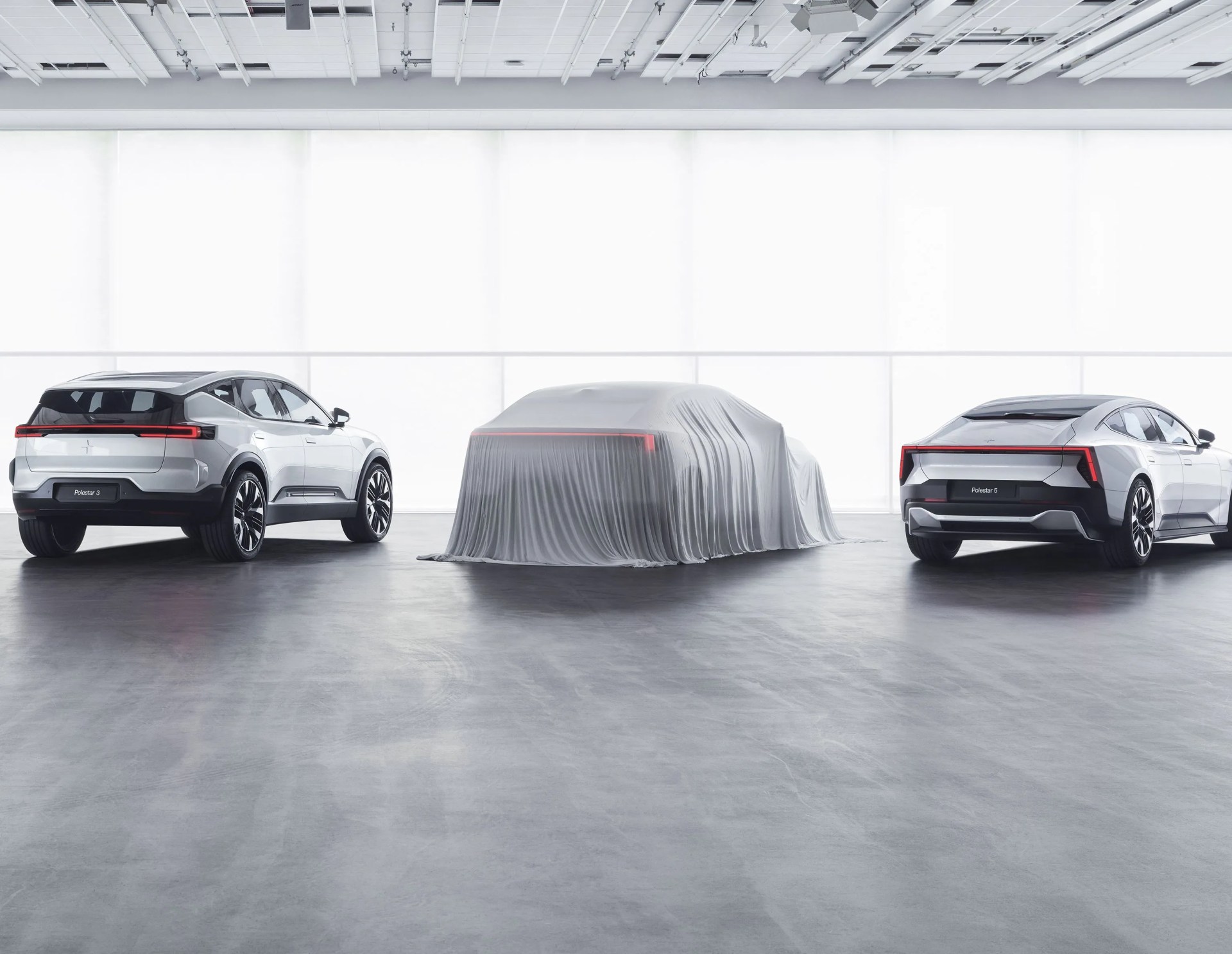 polestar 4 under a sheet parked between the polestar 3 and polestar 2