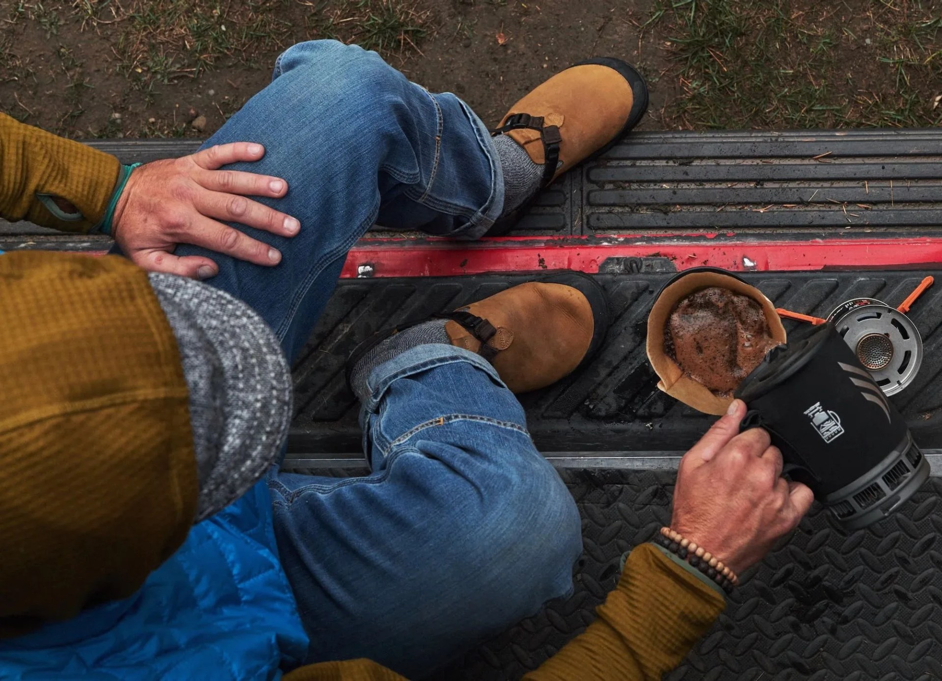man pouring coffee while wearing bedrock sandals leather mountain clog