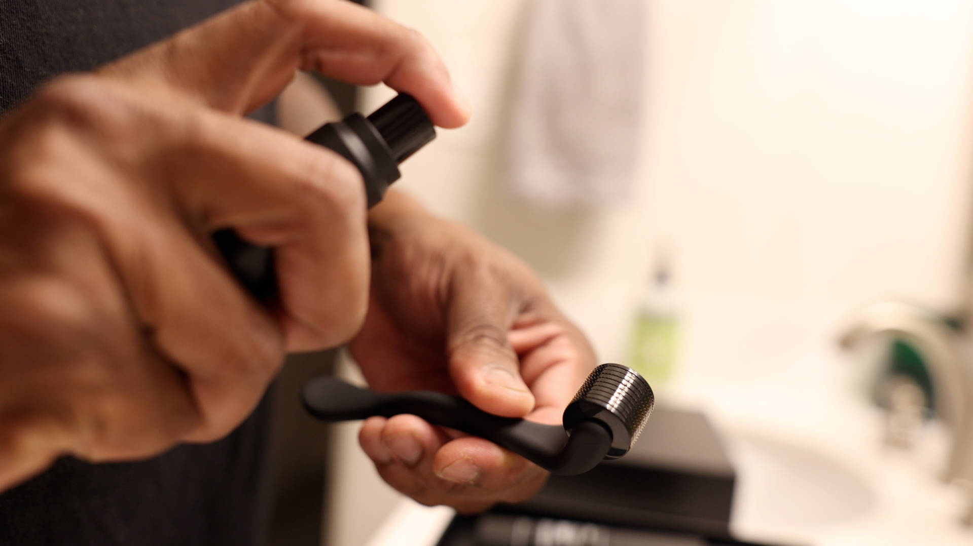a person spraying sanitizer on a face roller in a bathroom