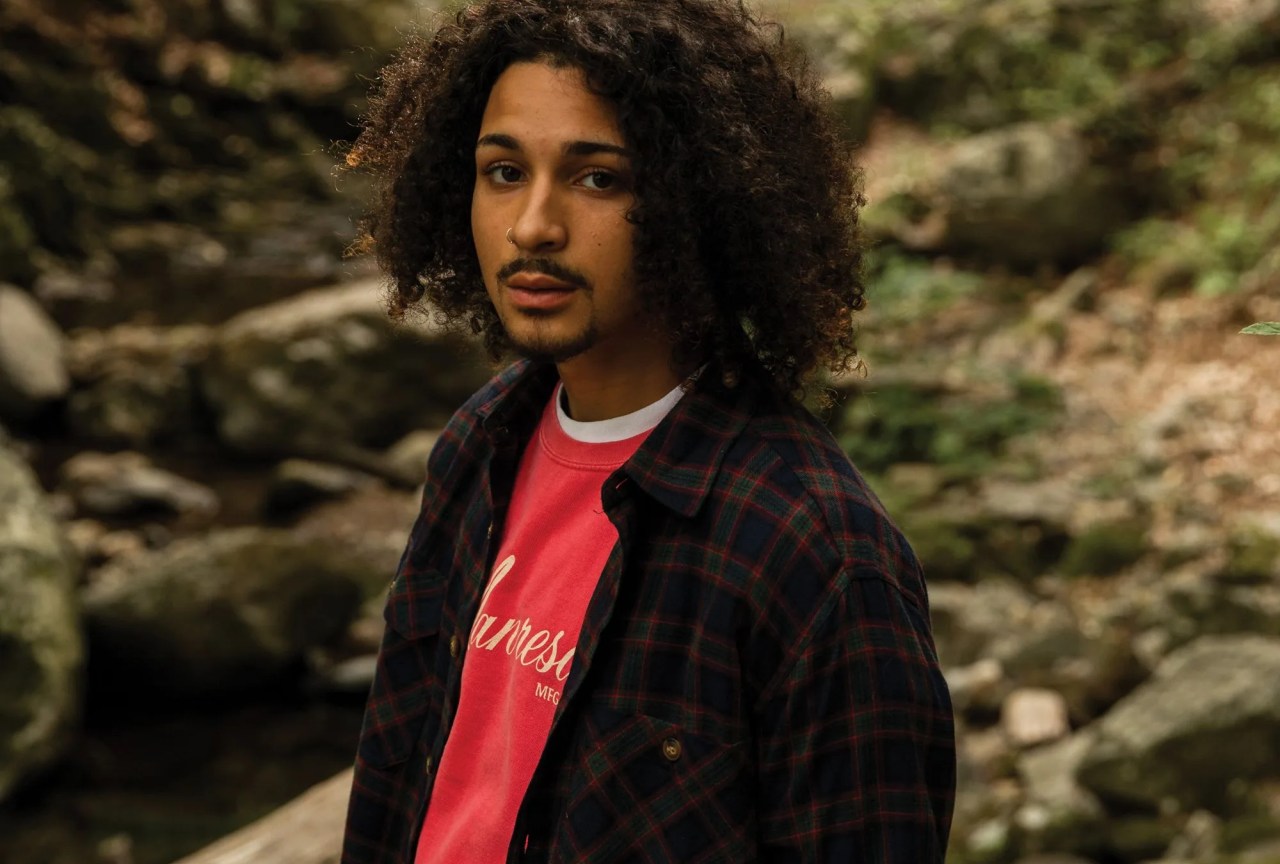 a man wearing a flannel in the woods