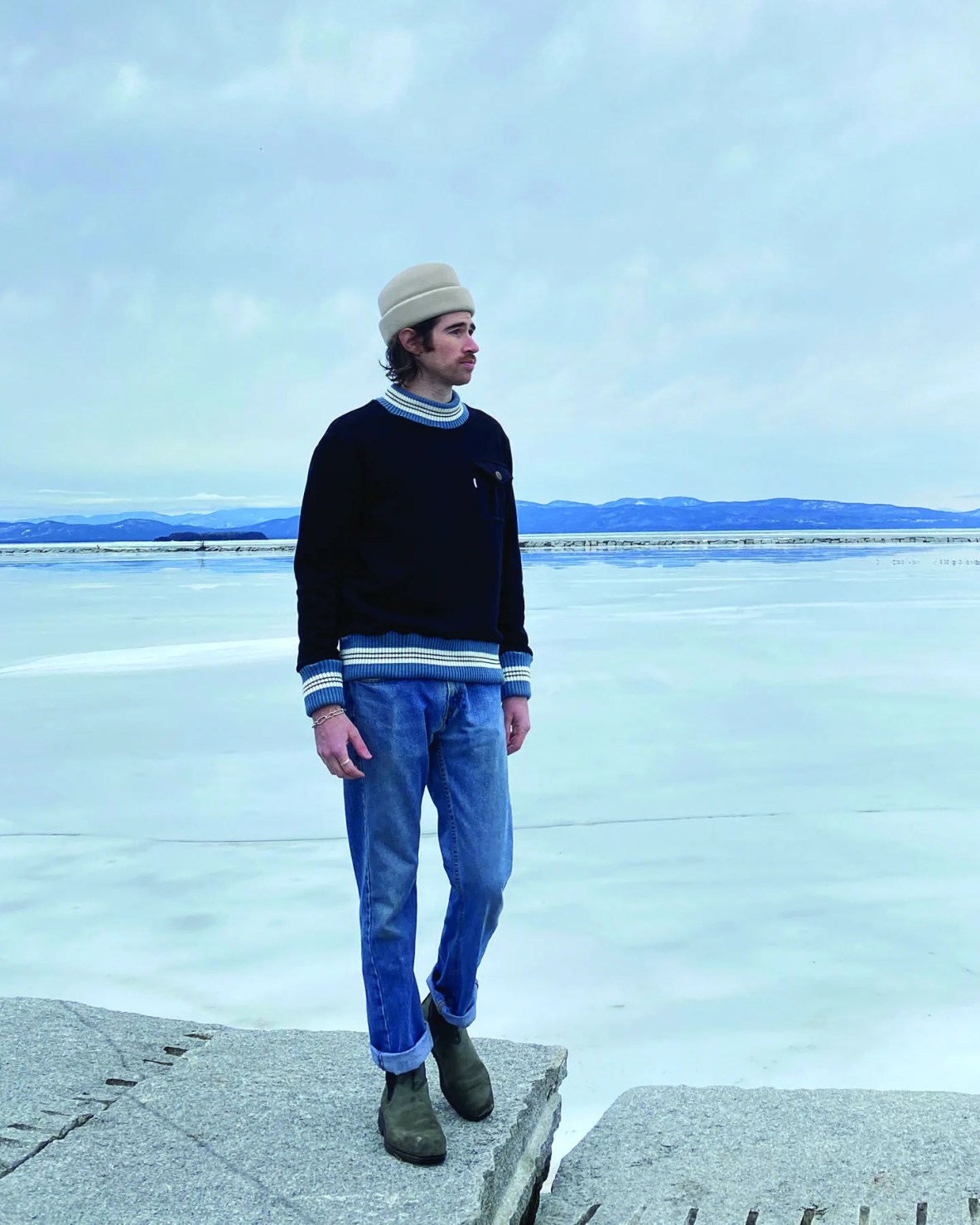 a man standing by a frozen lake