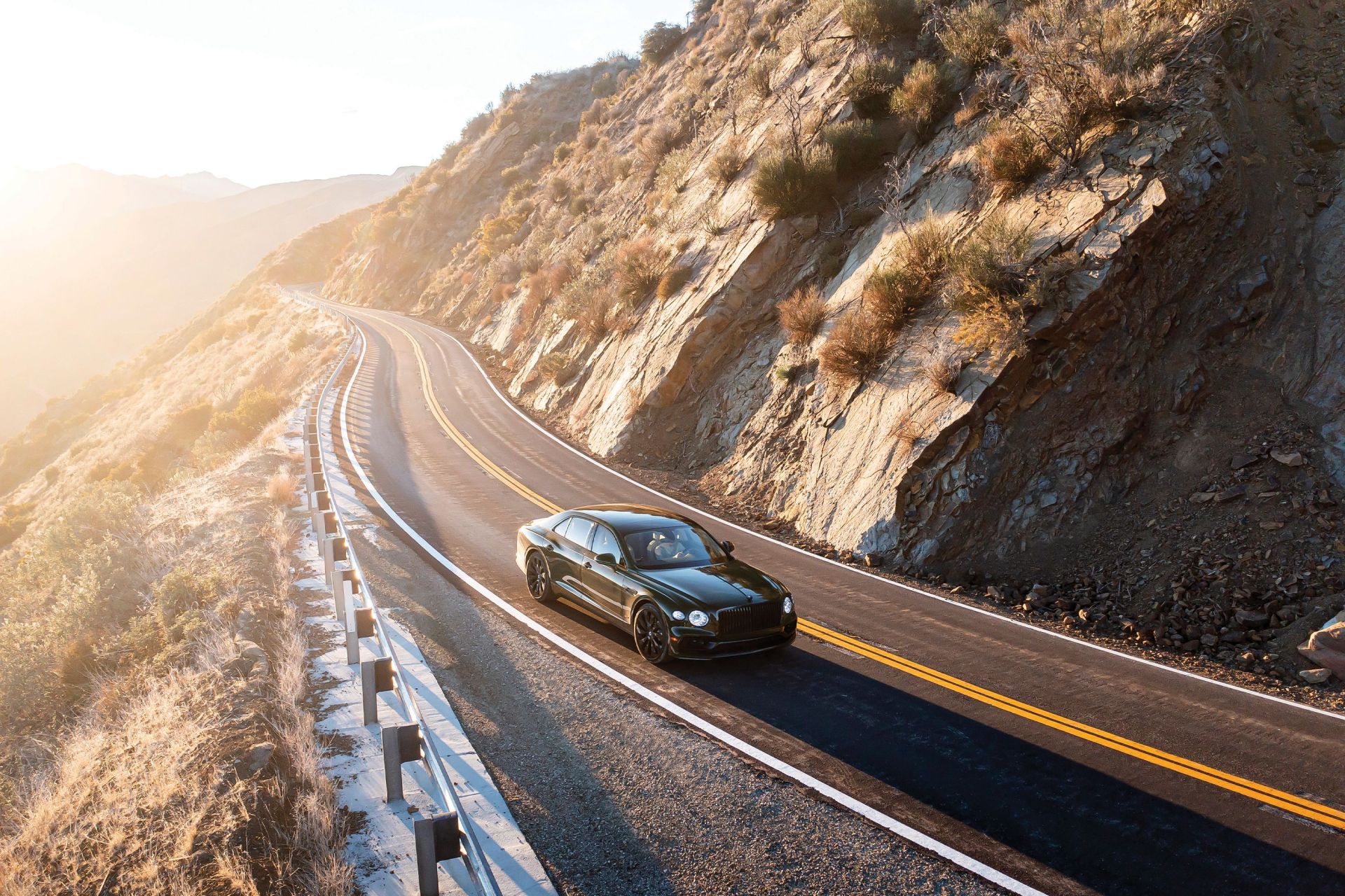 a bentley driving on a mountainous road