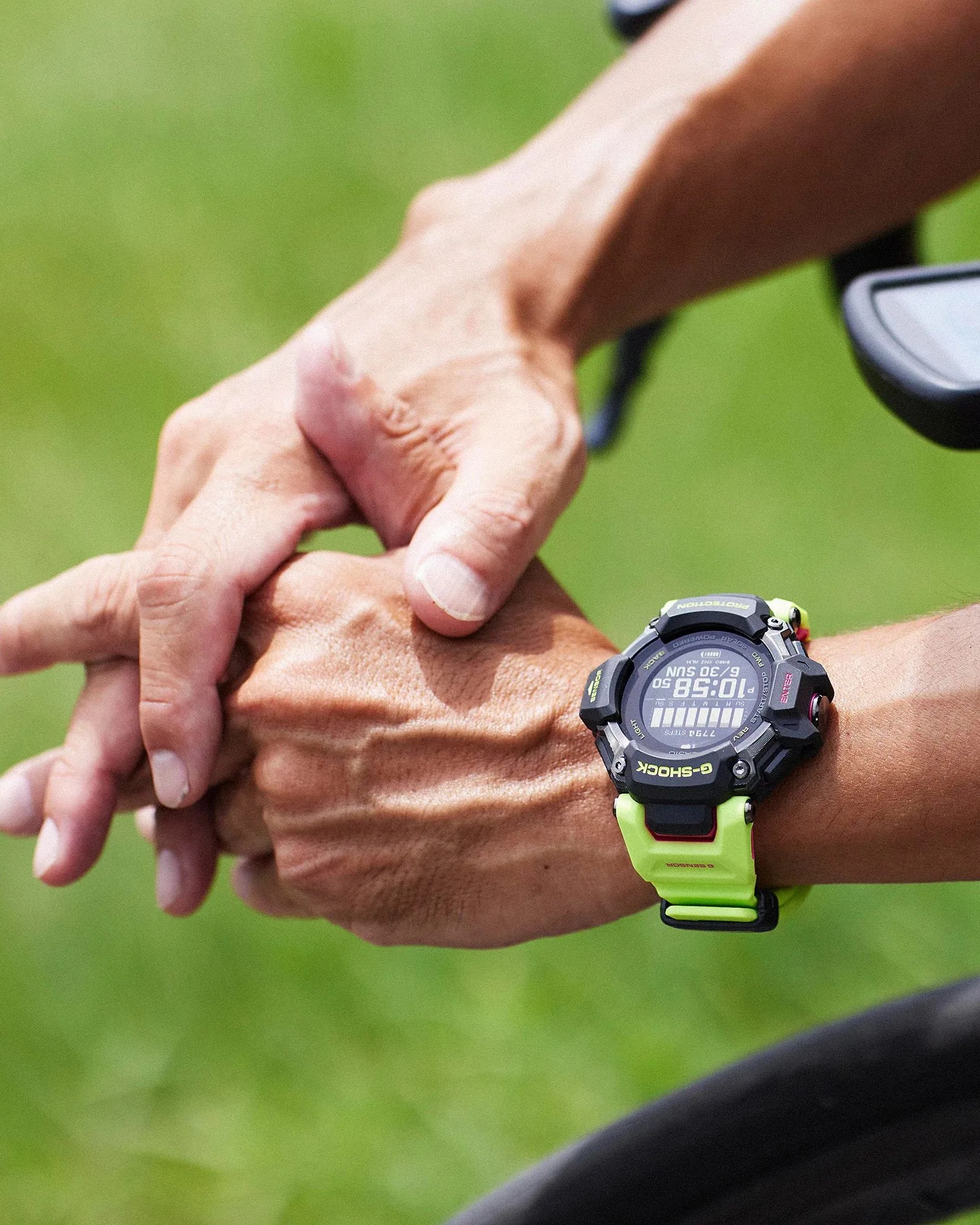 casio g shock watch worn on wrist of clasped hands on a bike