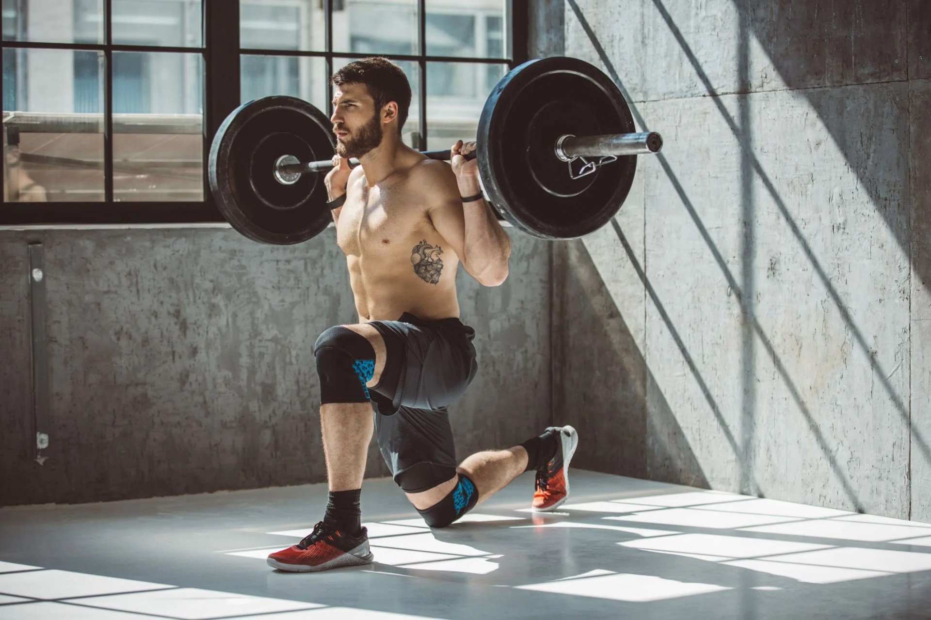 young man exercising deadlift in gym professional athlete wearing sports clothing