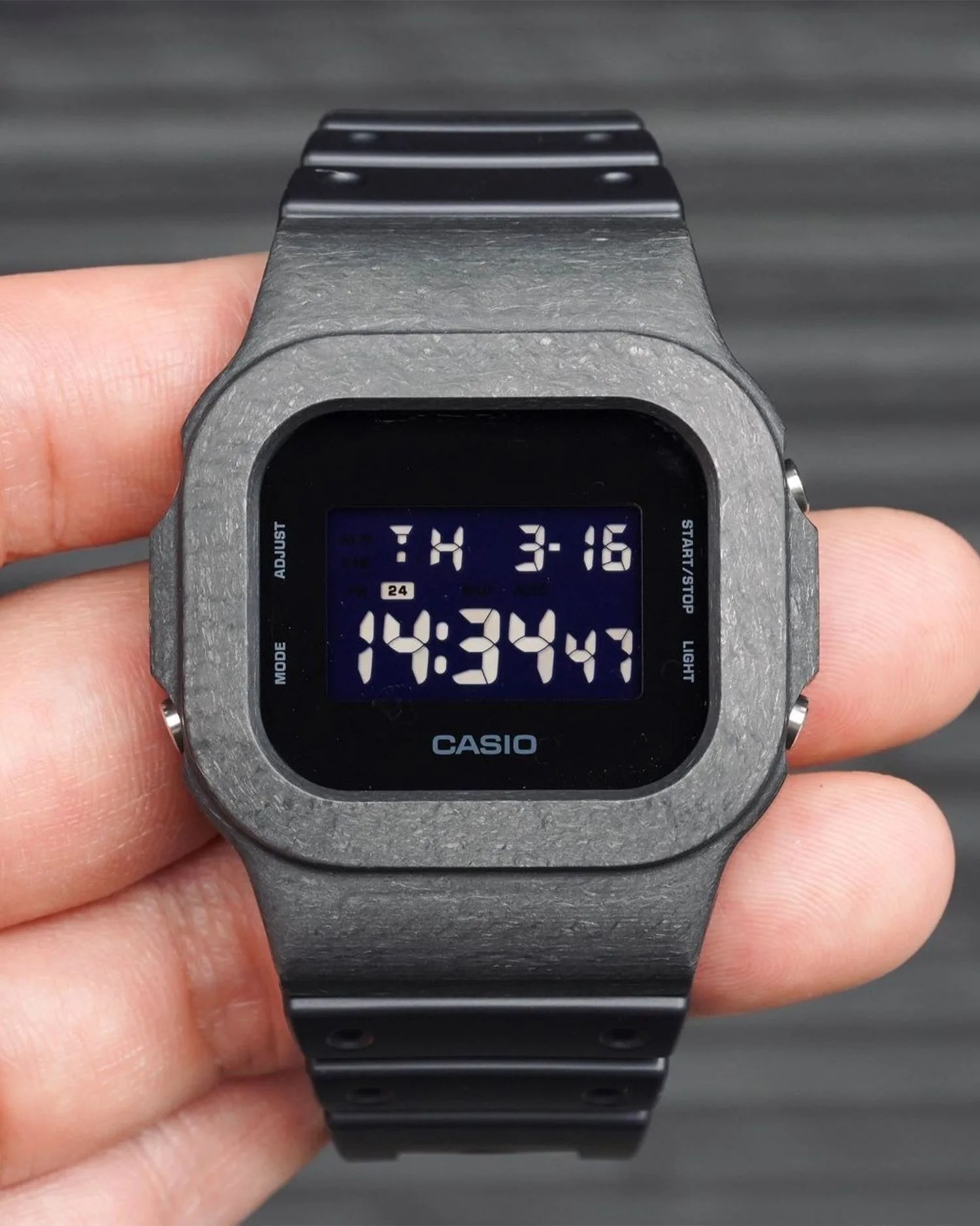 damue 5600 carbon watch in a persons hand