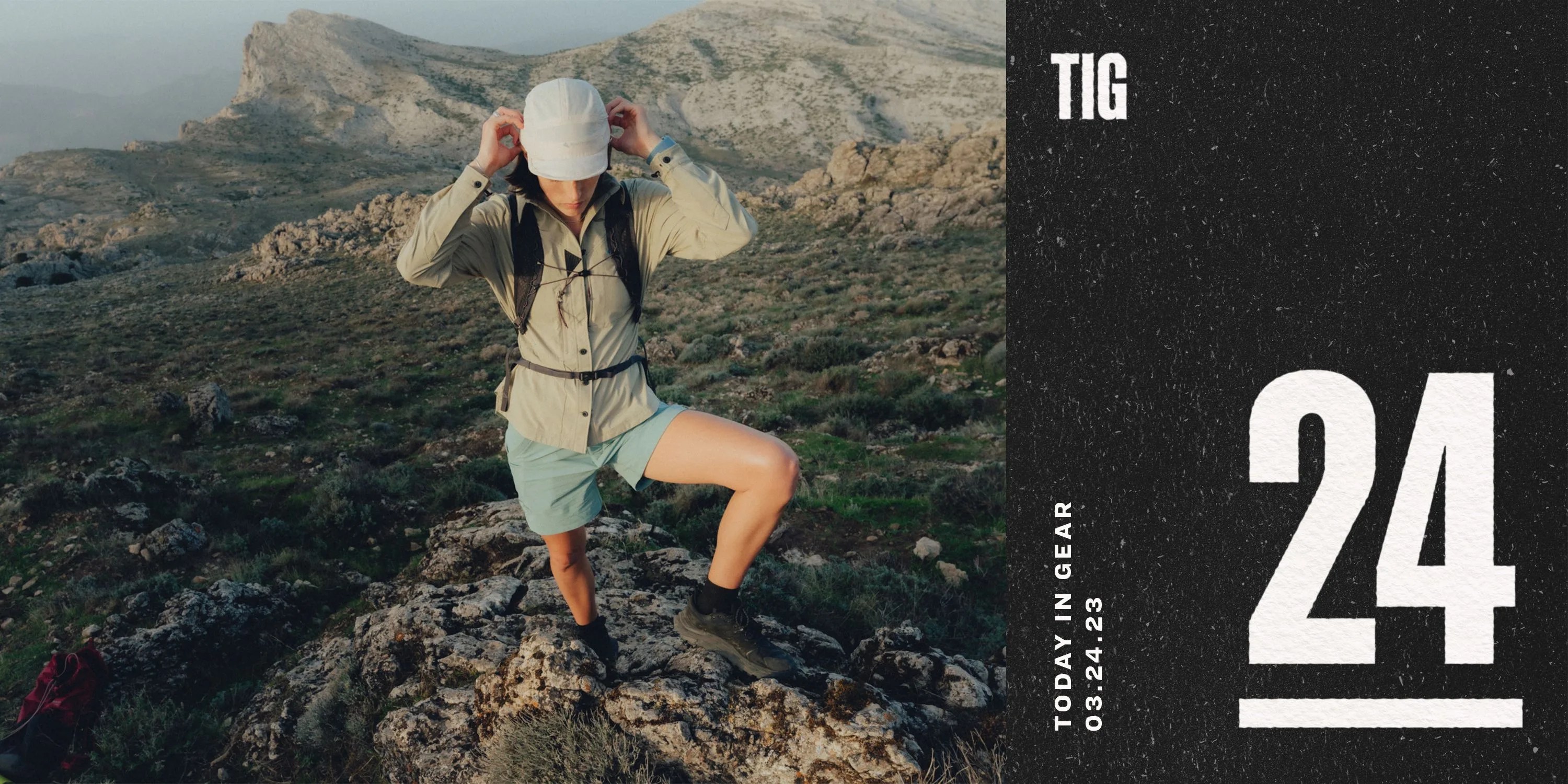 a person on top of a mountain wearing a hat, jacket, and shorts