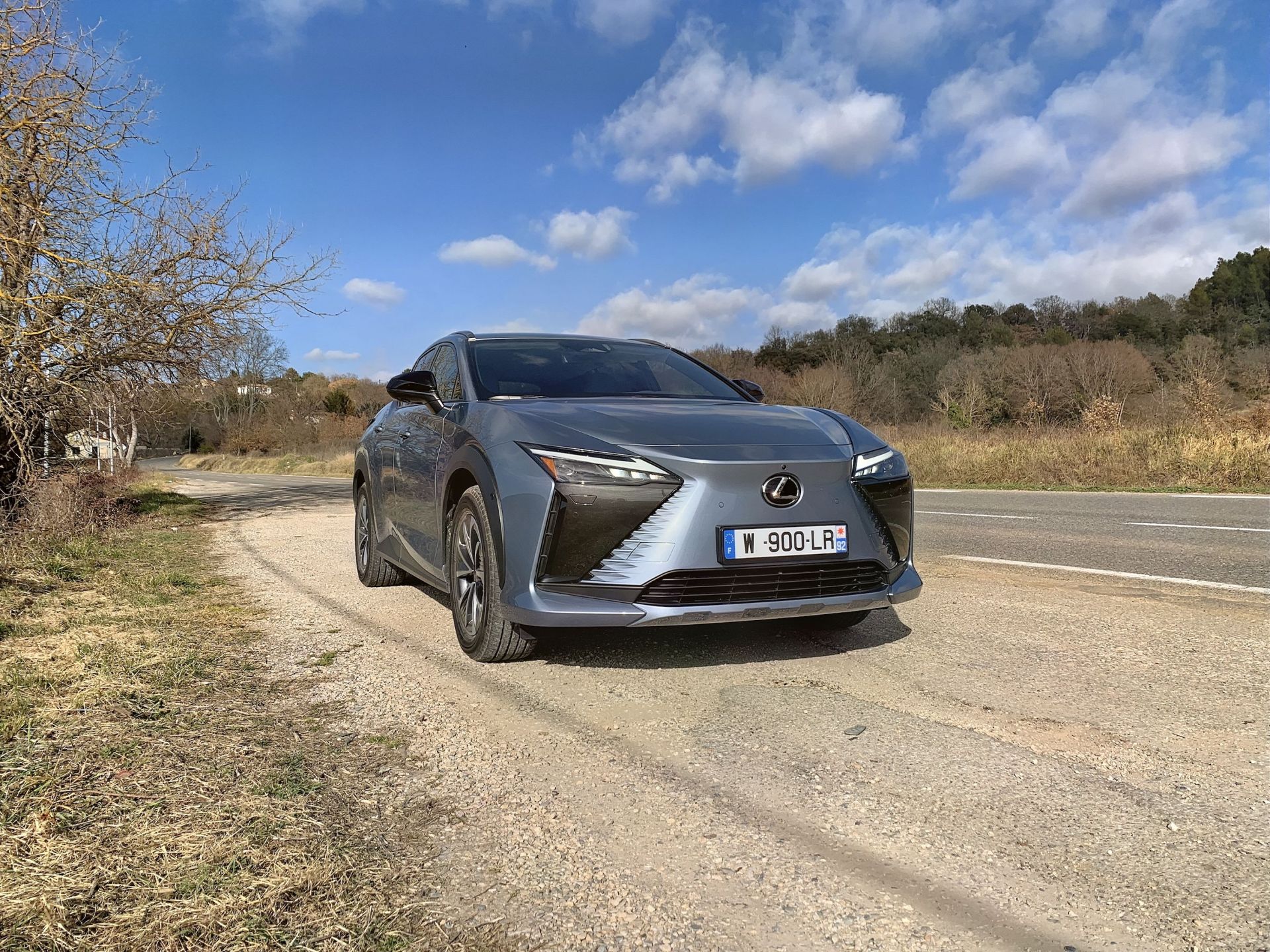 lexus rz parked by the side of a rural road