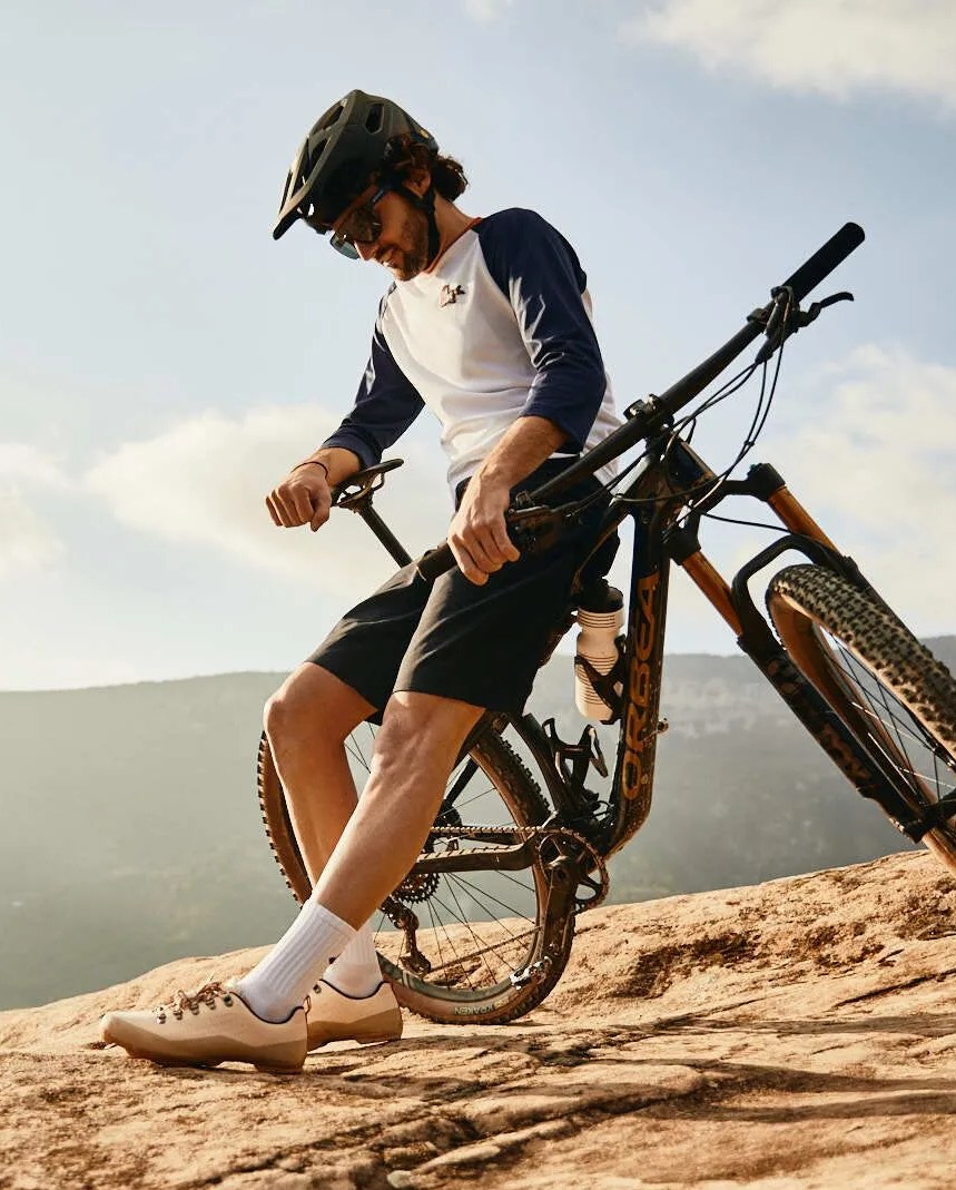 man leaning against bike wearing café du cycliste gear
