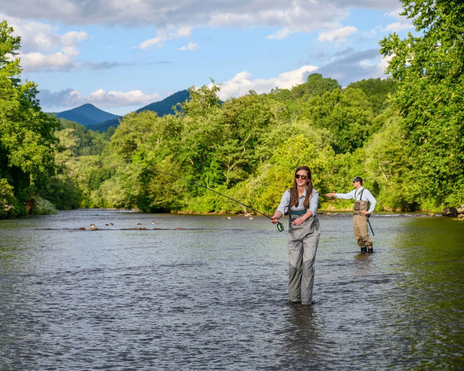 two people fishing in river