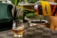 whiskey being poured from a bottle to a glass