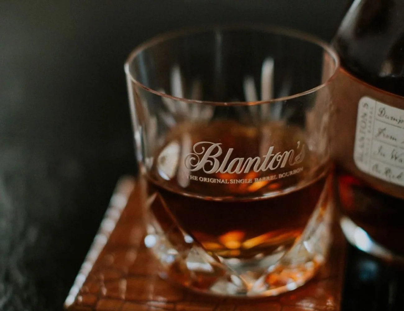 a glass of bourbon on a table