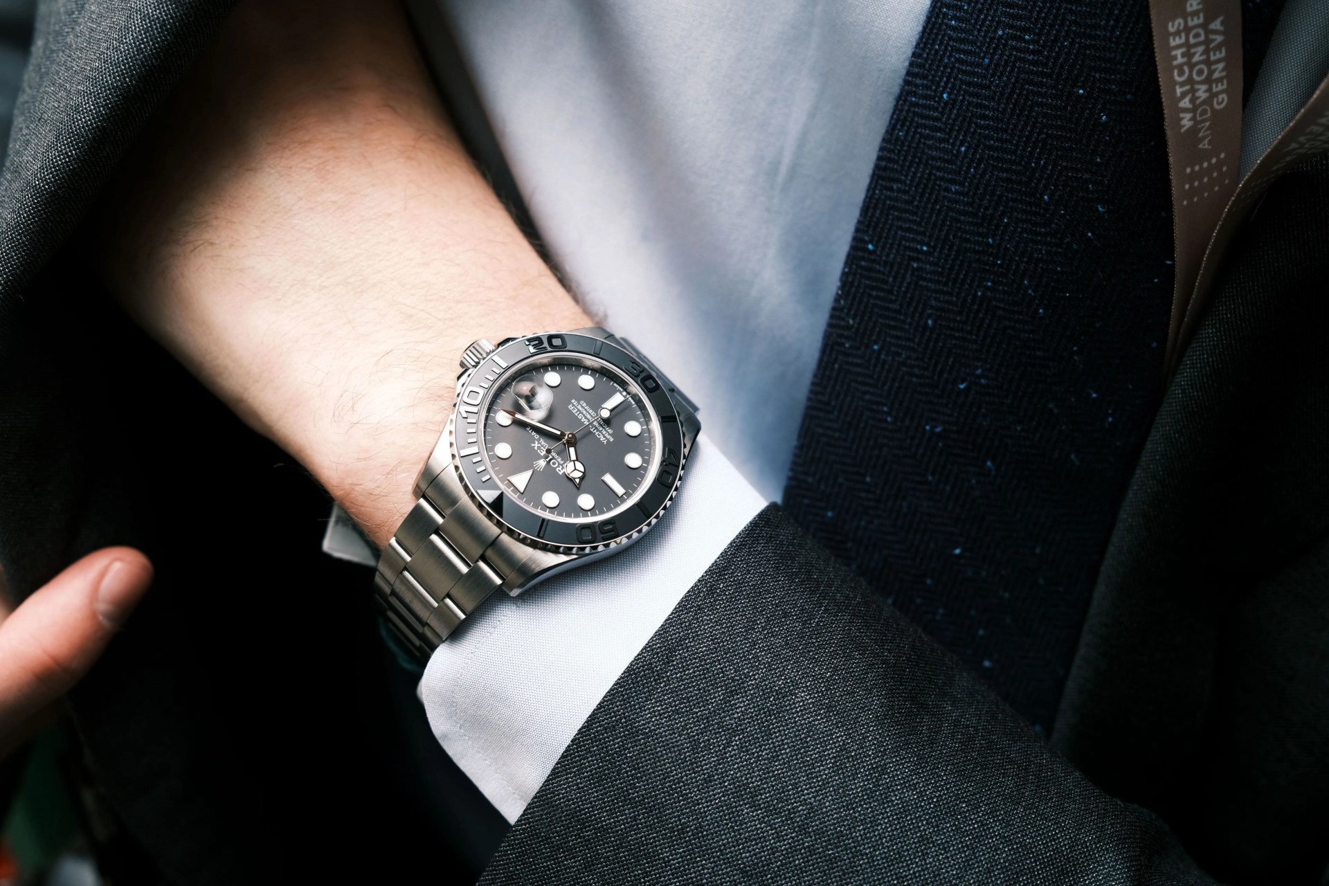 rolex yacht master watch on wrist of man in suit