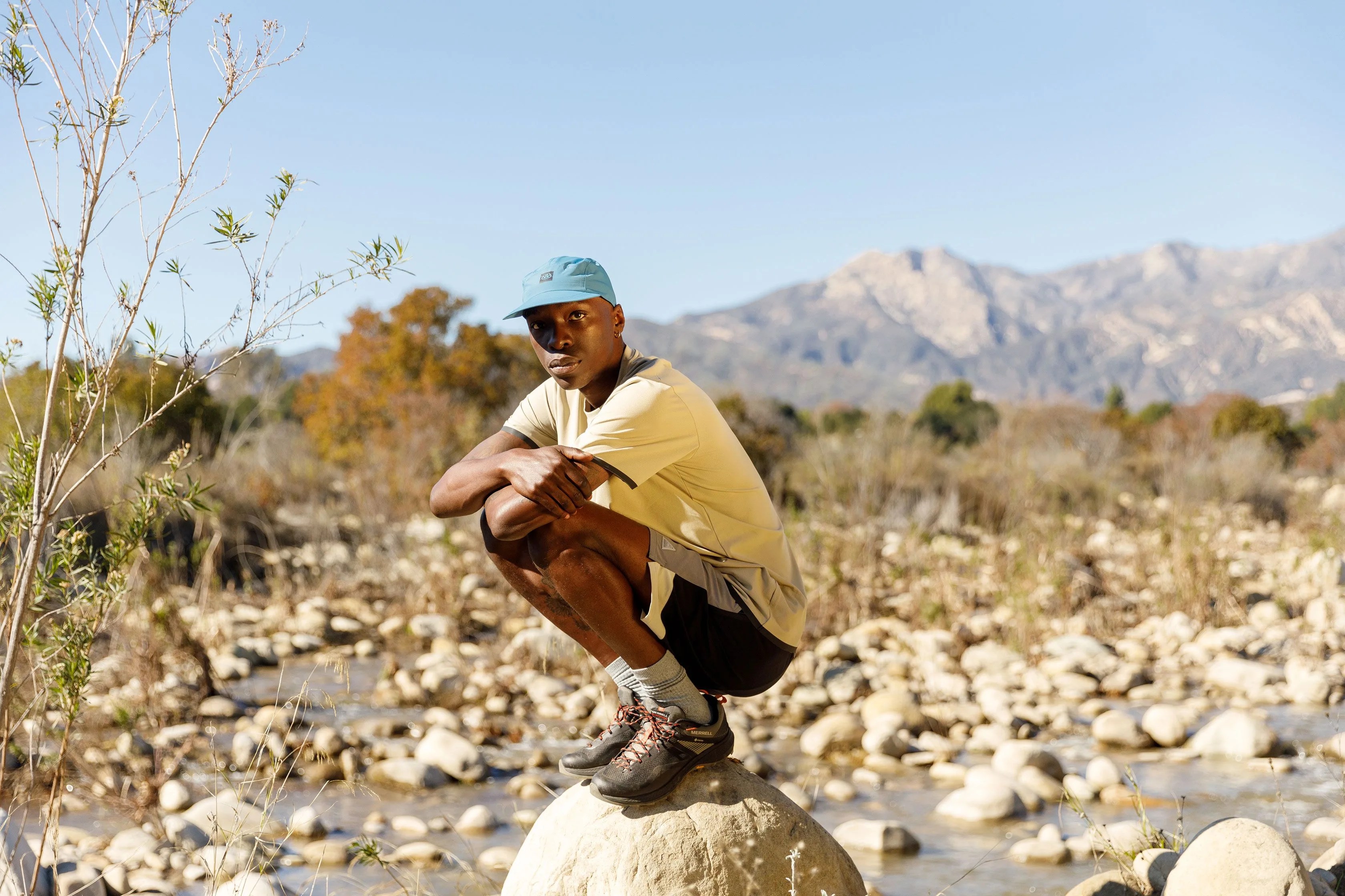 man squatting on rock wearing 686 clothing