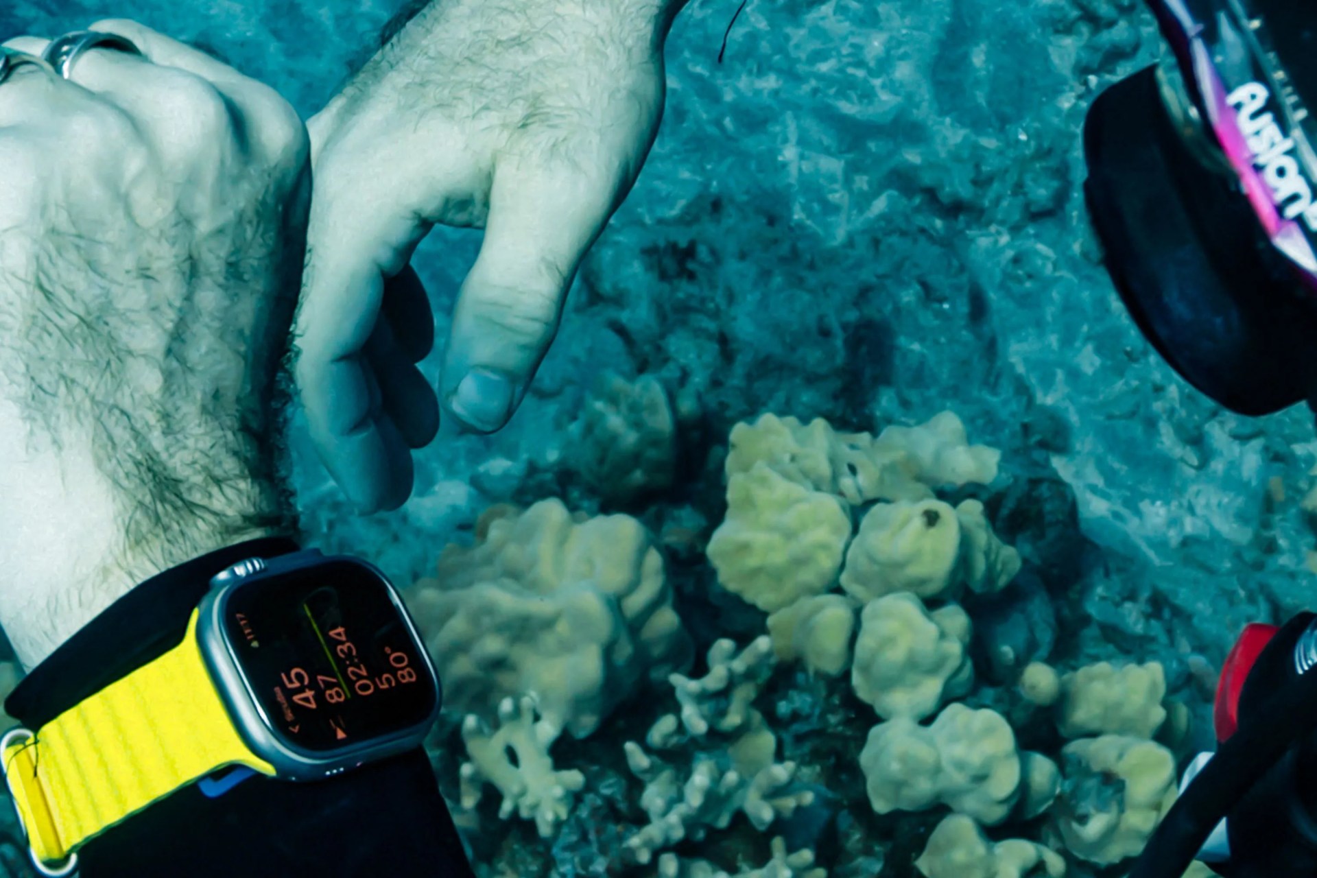 a person scuba diving wearing an apple watch ultra
