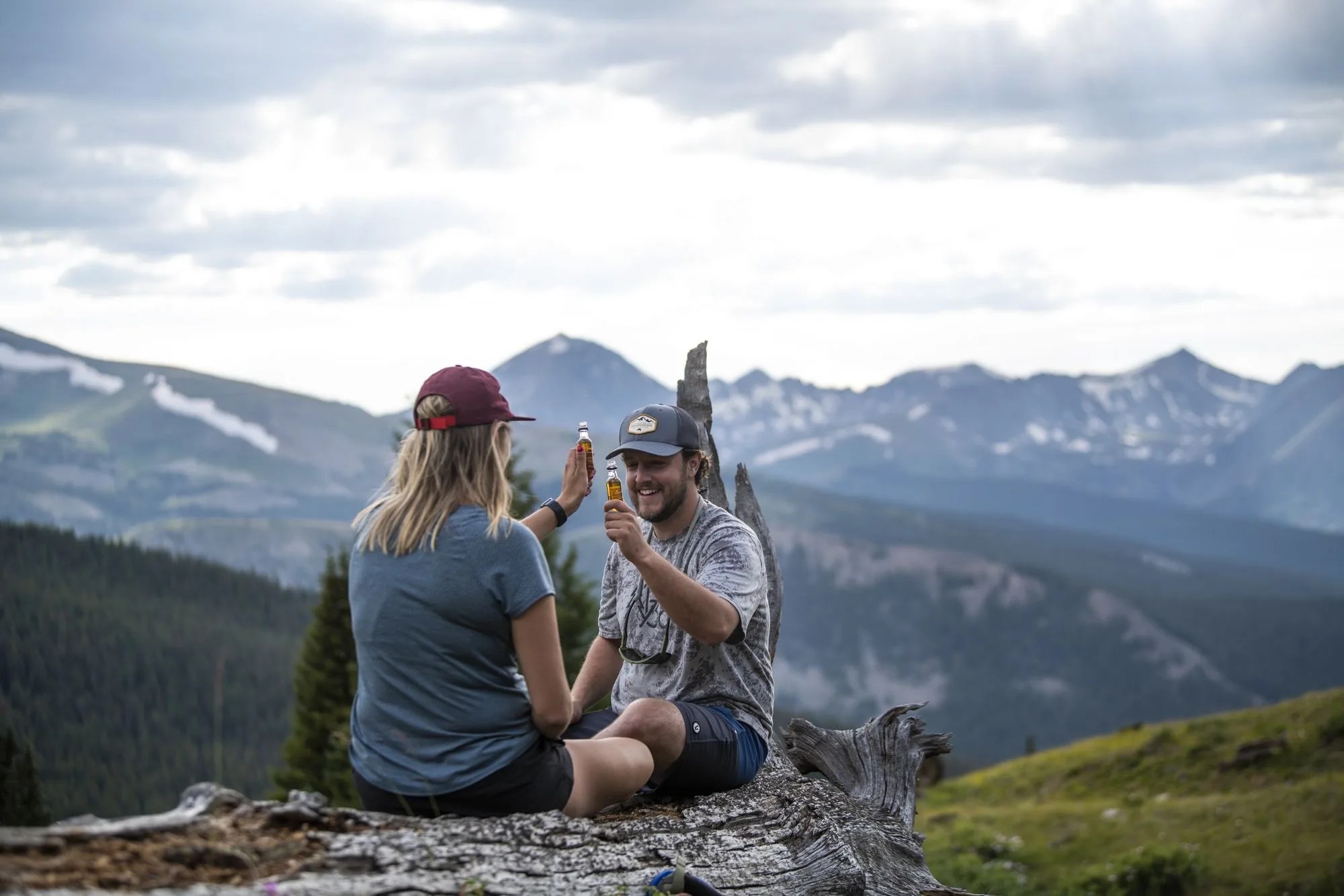 two men clicking their breckenridge distillery beer bottles at hike
