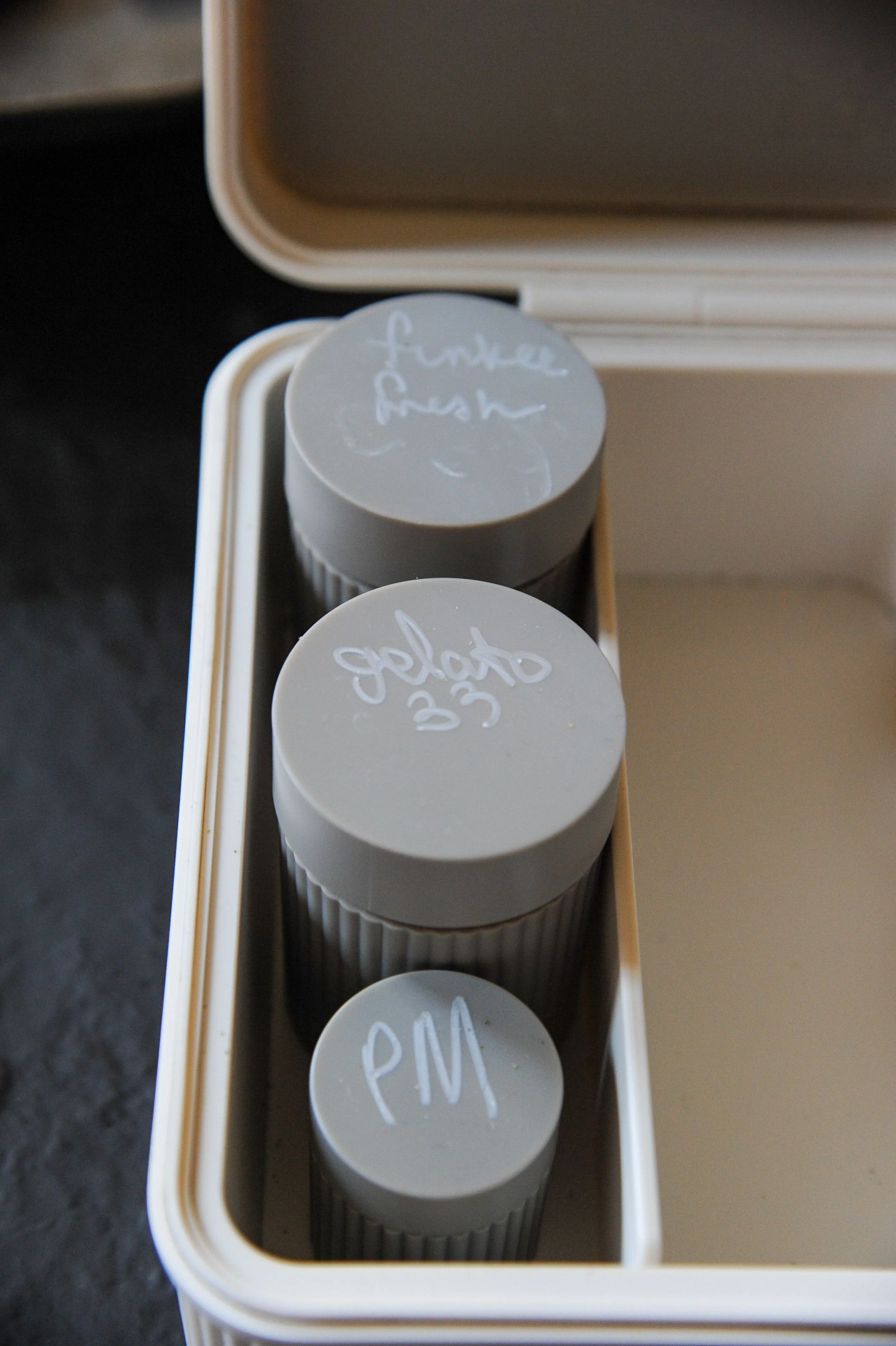 three canisters with hand written labels on the lids sitting in a tulip modular lockbox