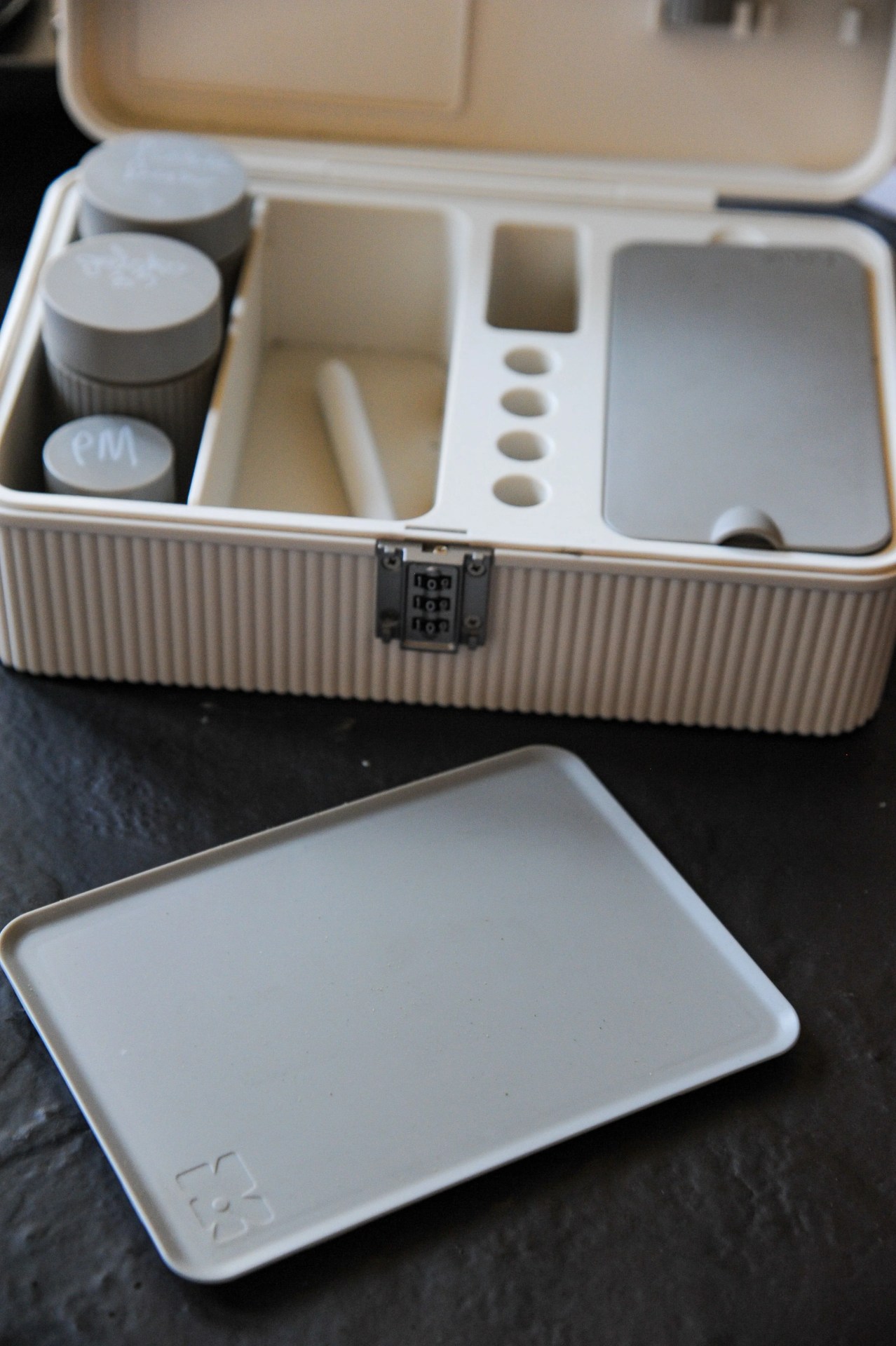 a close up of an open tulip modular lockbox and plastic tray on a coffee table