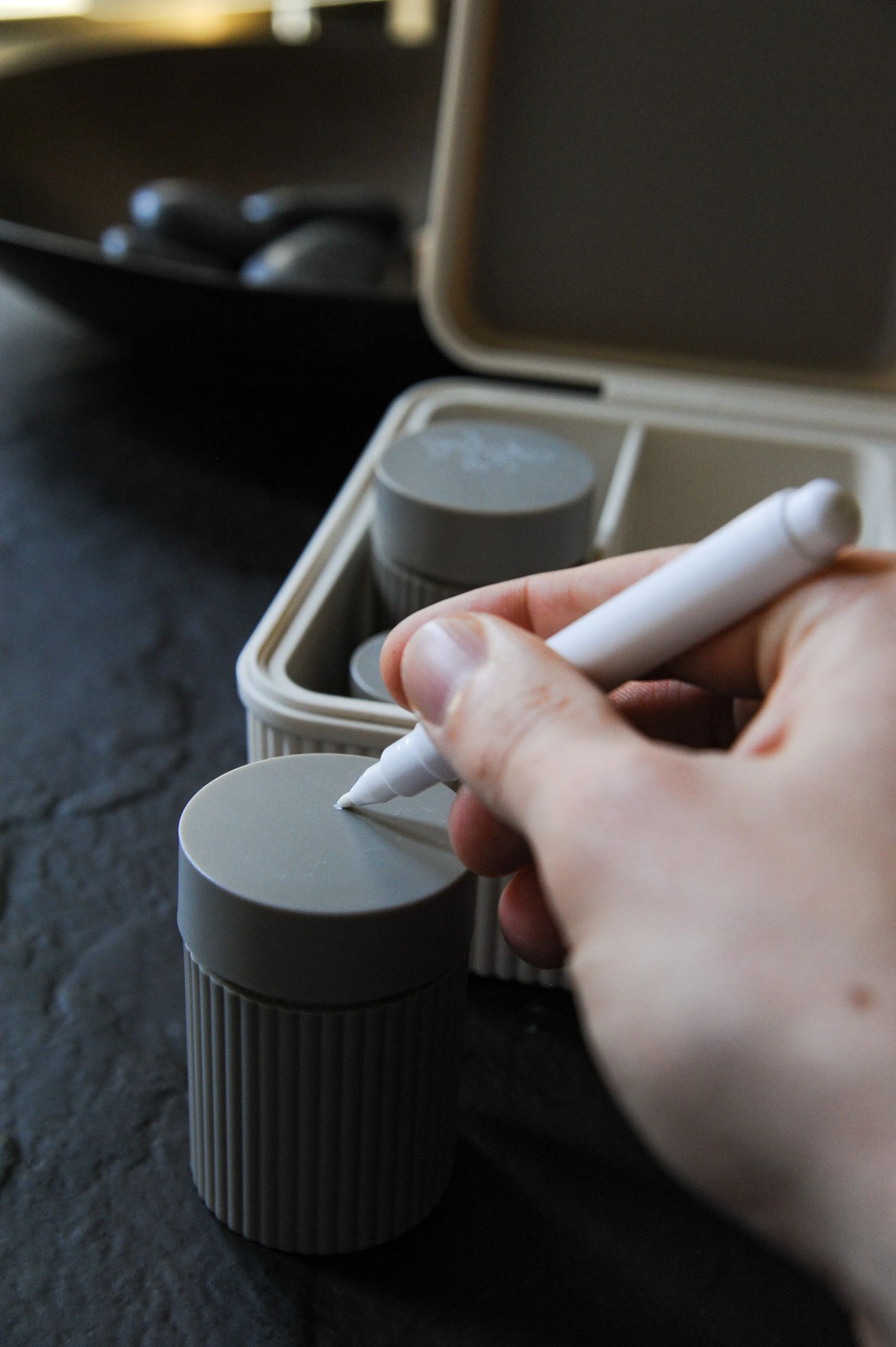a person writing on the lid of a weed canister
