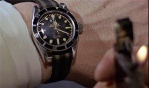 james bond in goldfinger checking his rolex submariner on a nato strap by the light of his zippo lighter