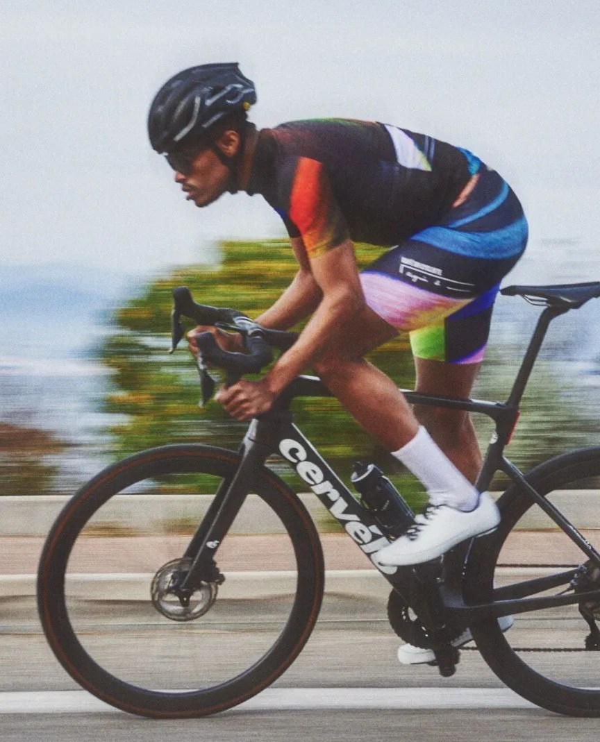man riding bike on road wearing cafe du cycliste gear