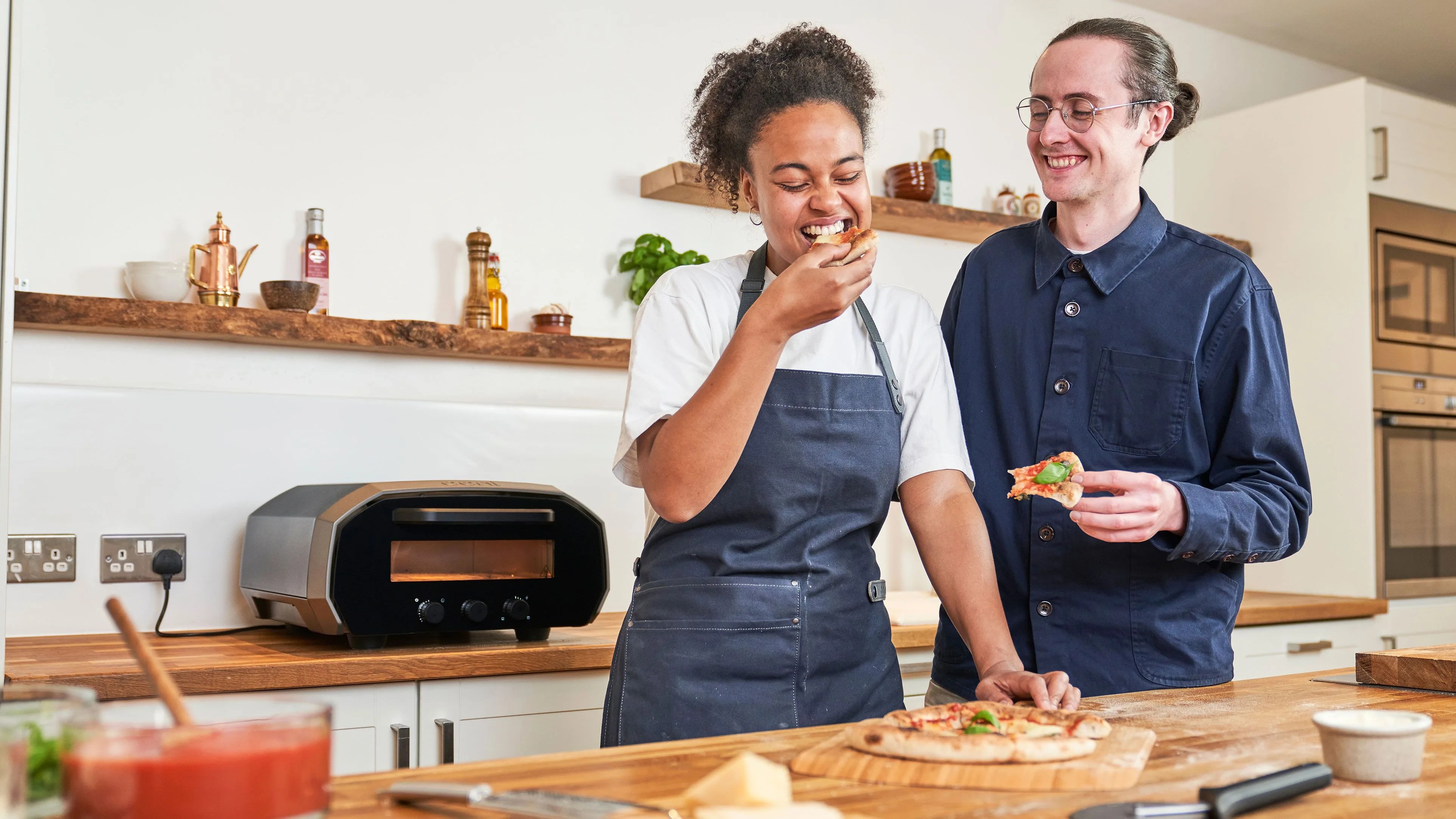 man and woman eating pizza made from ooni oven