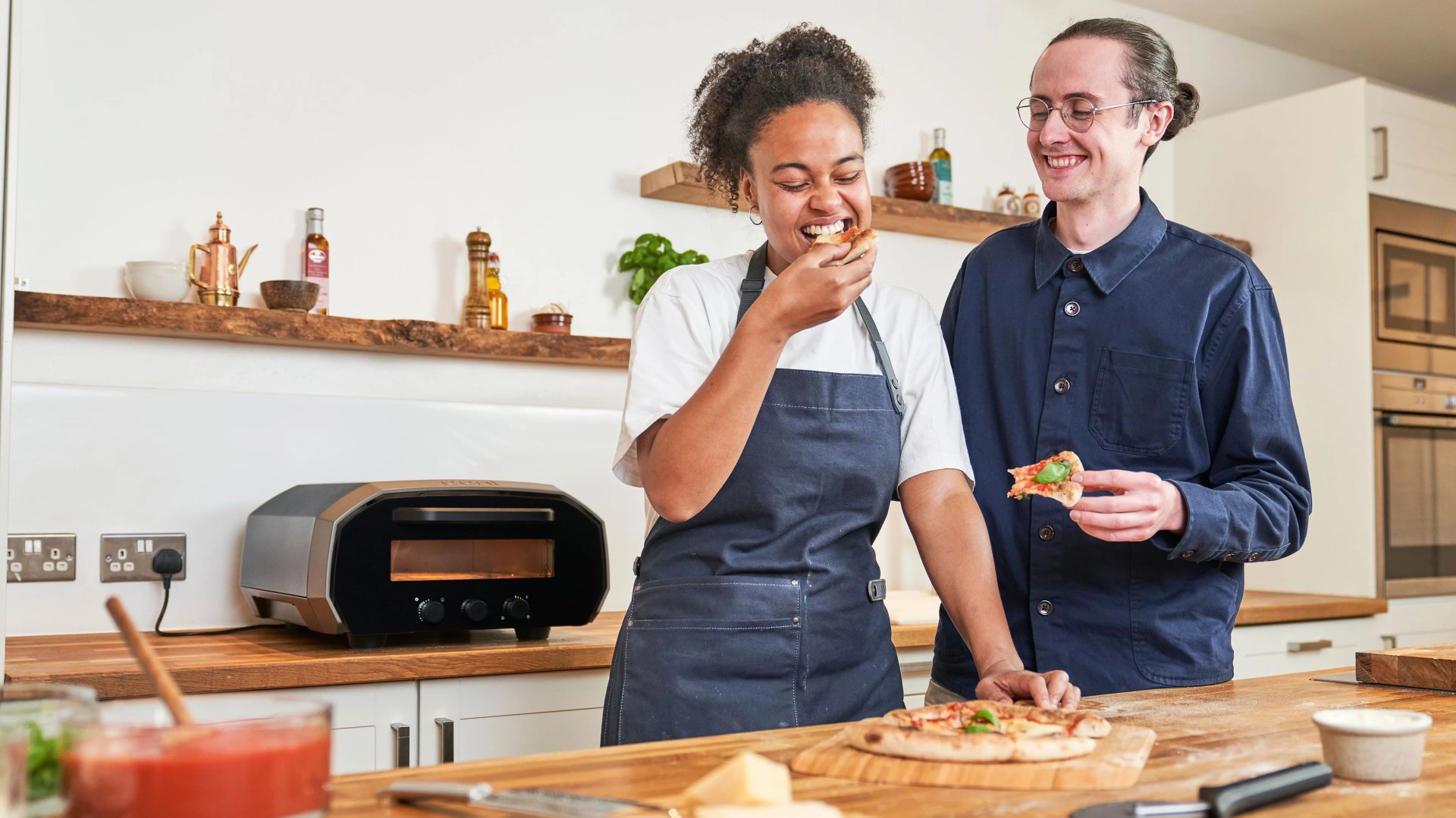 man and woman eating pizza made from ooni oven