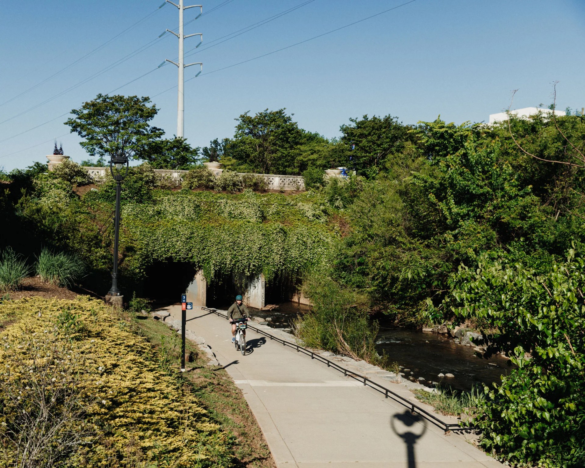person biking underneath bridge