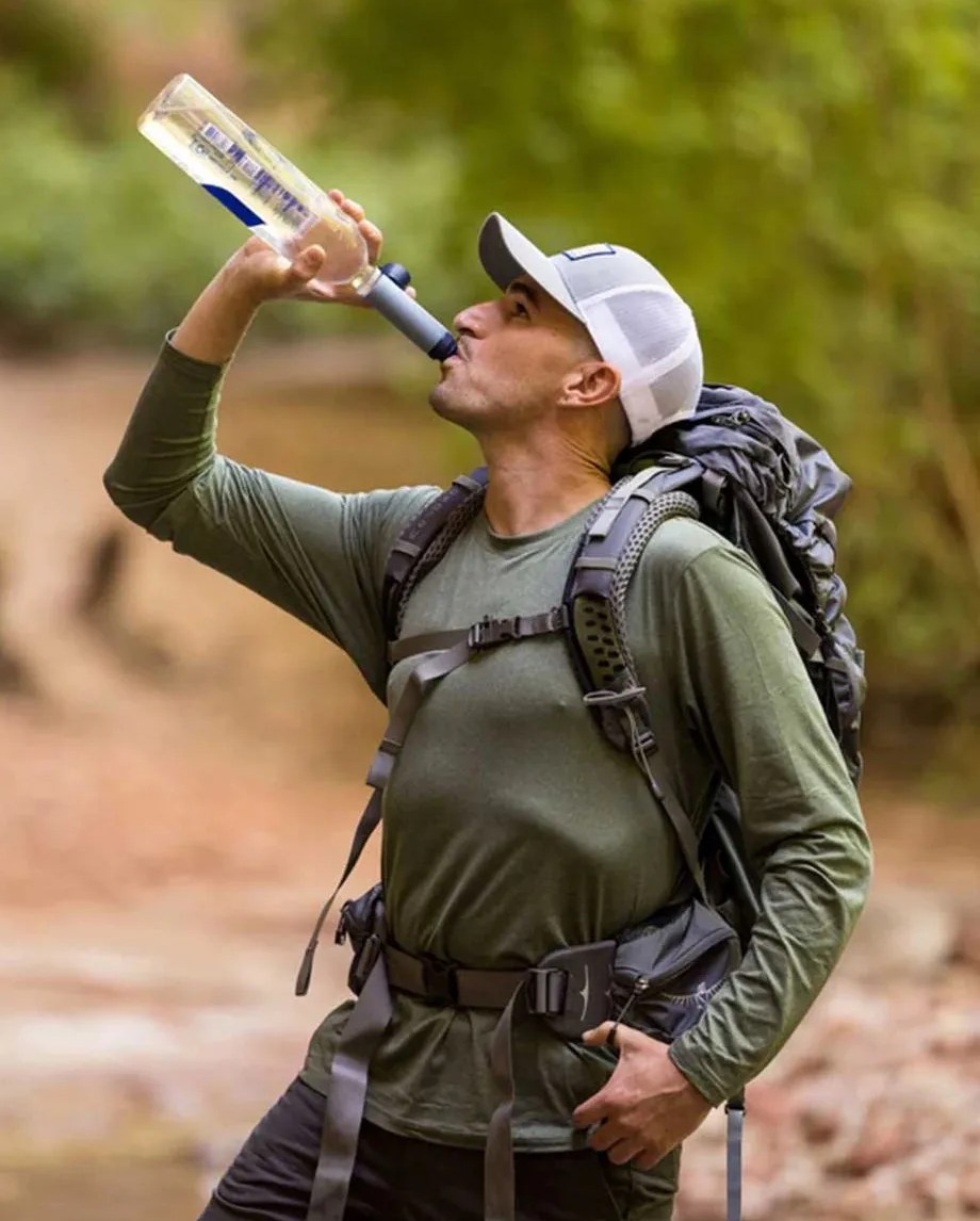 man using lifestraw peak series solo filter to drink from bottle