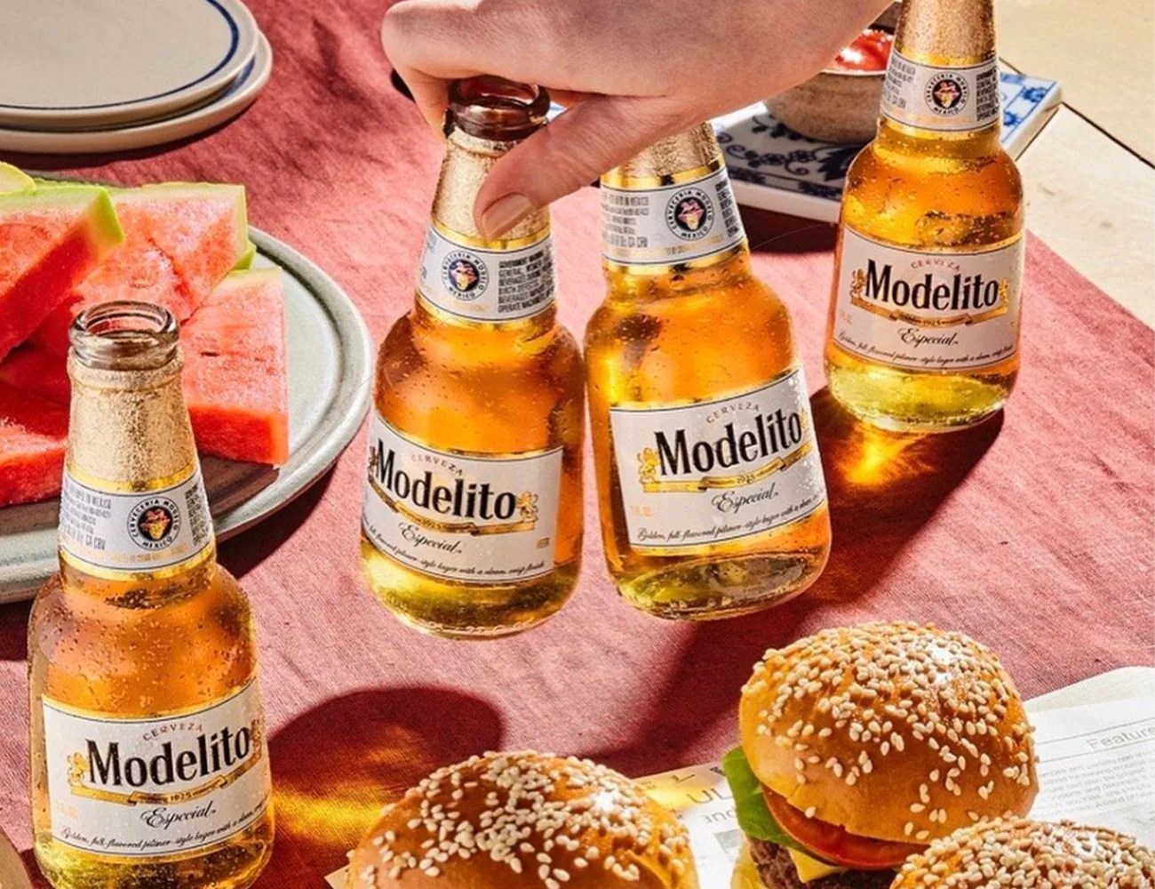 modelo beer bottles next to some burgers