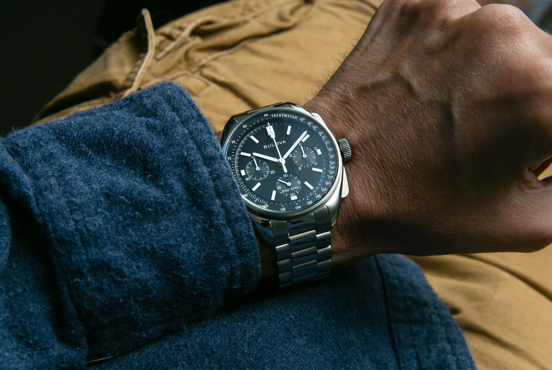 bulova chronograph on a wrist with blue shirt and yellow pants