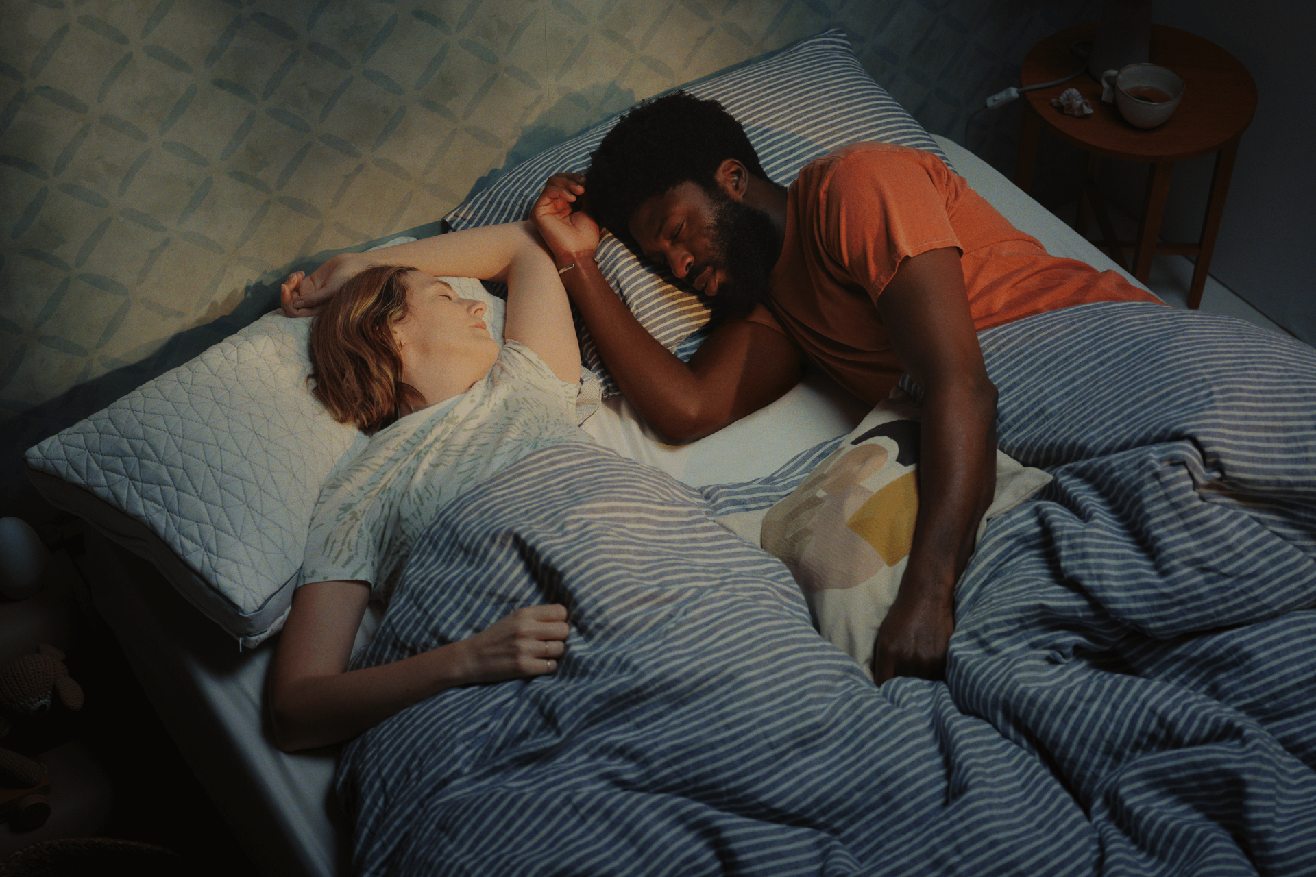 man and woman sleeping next to each other in bed using coop pillows