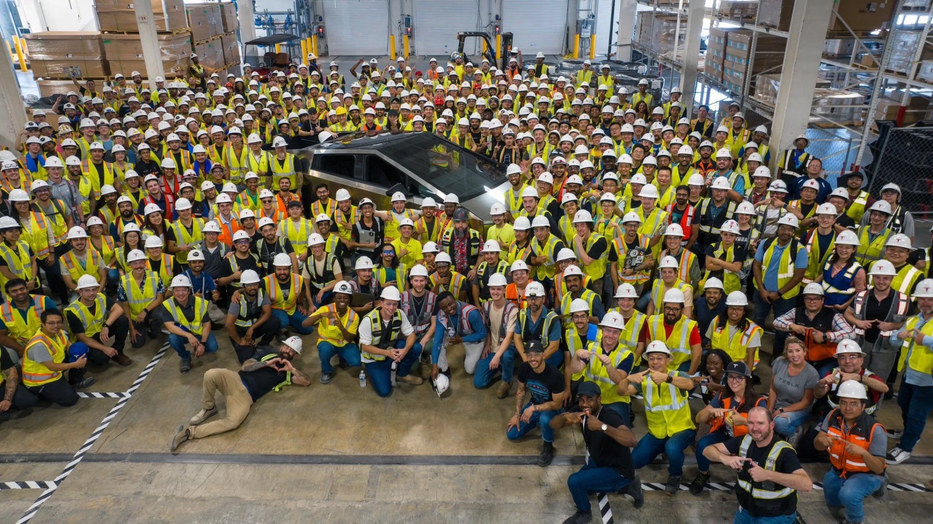 first production cybertruck shrouded by employees