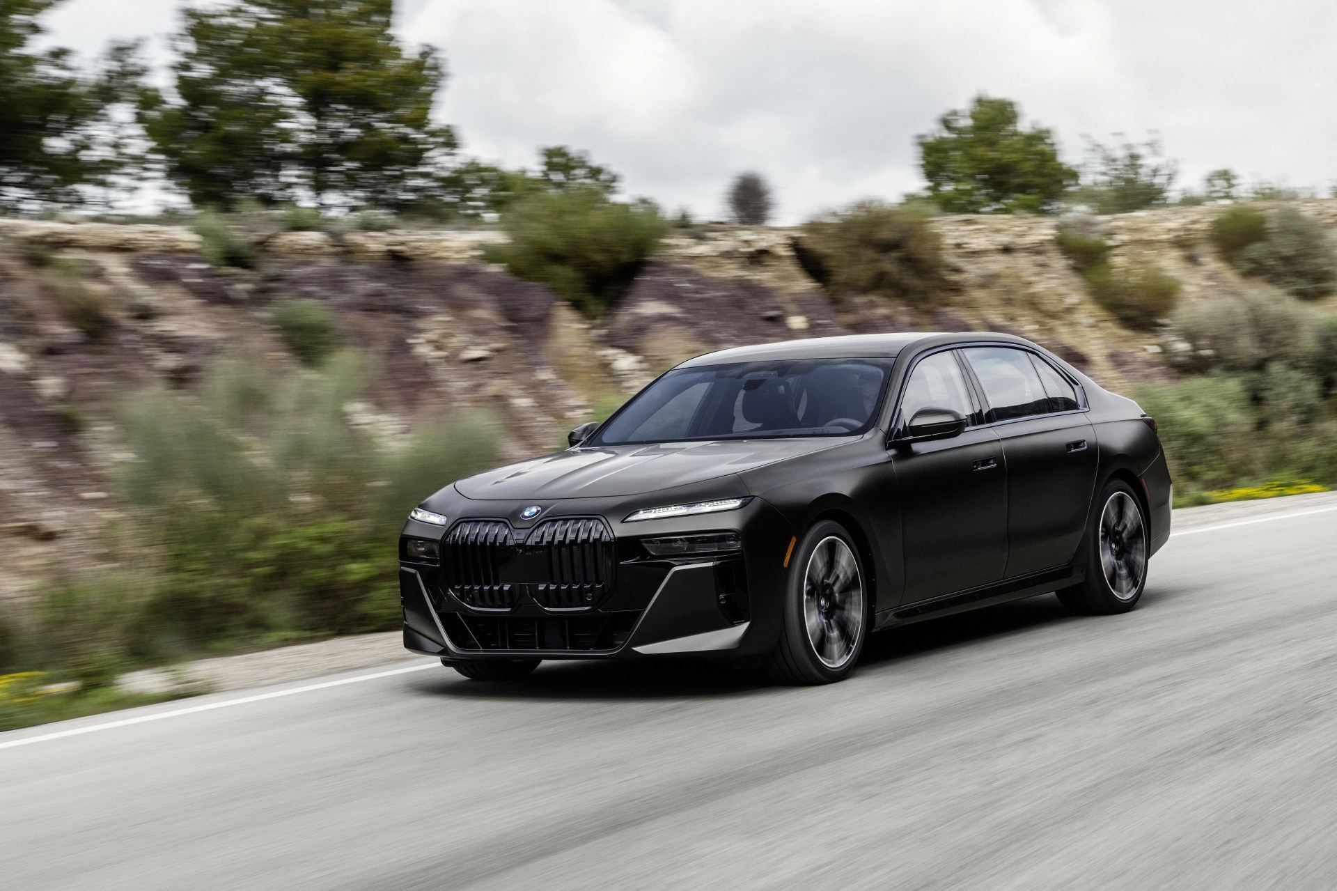 black bmw 7 series driving on road