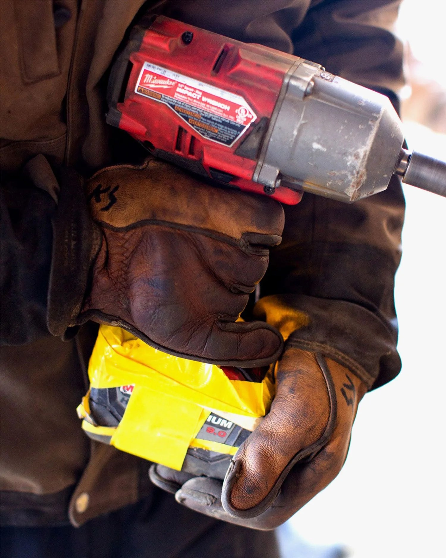 man using vermont glove holding power drill