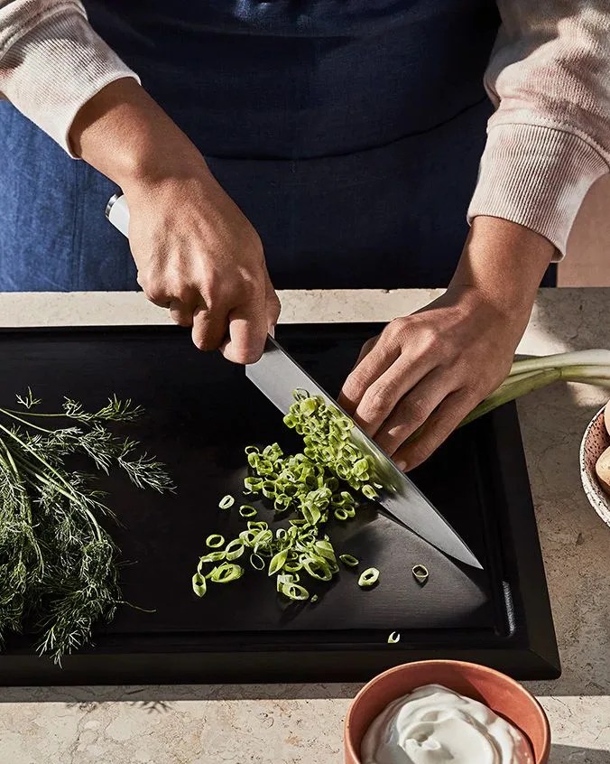 man cutting green onions with material knife