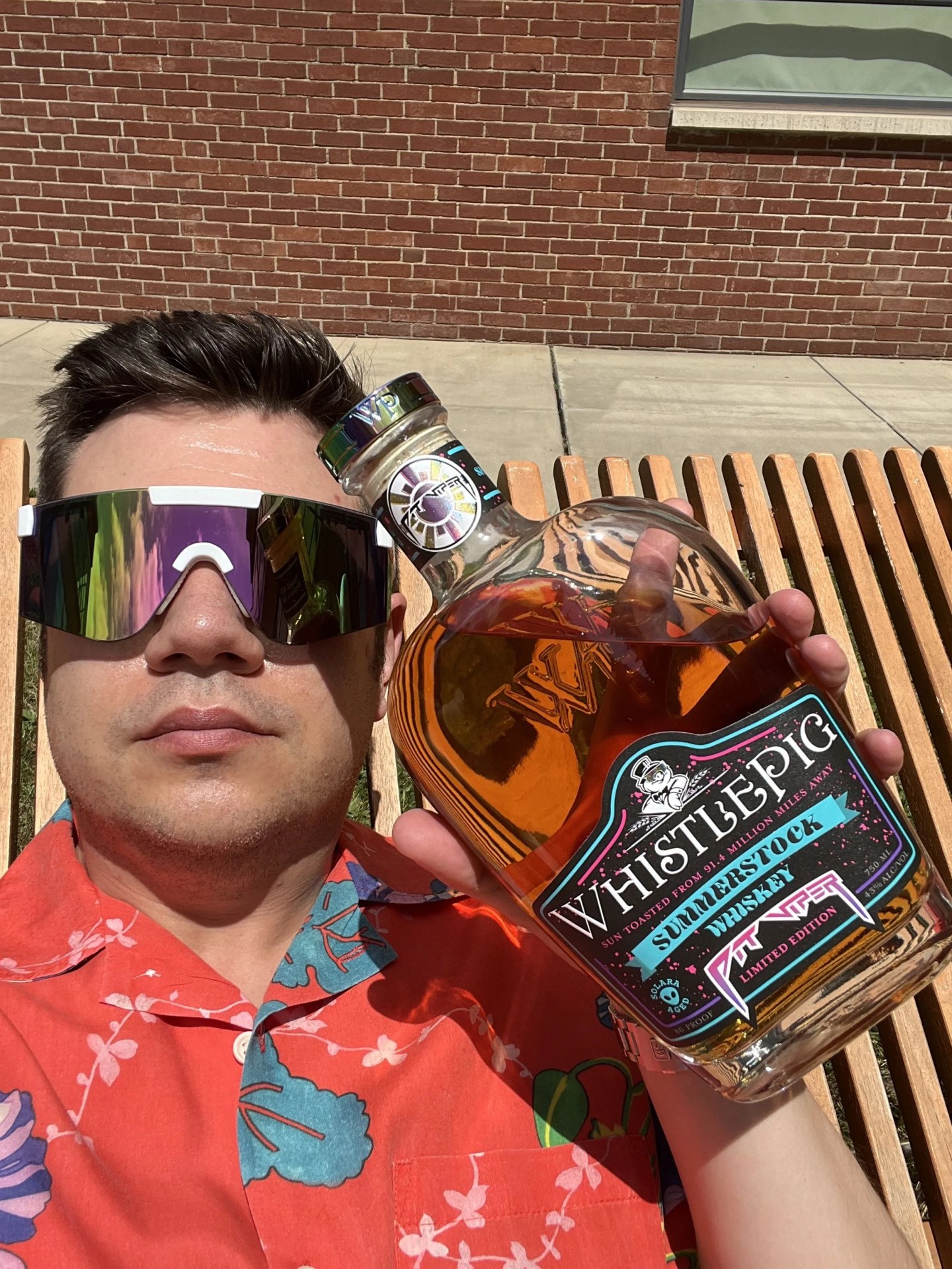 whistlepig summerstock whiskey held by man in aloha shirt and sunglasses