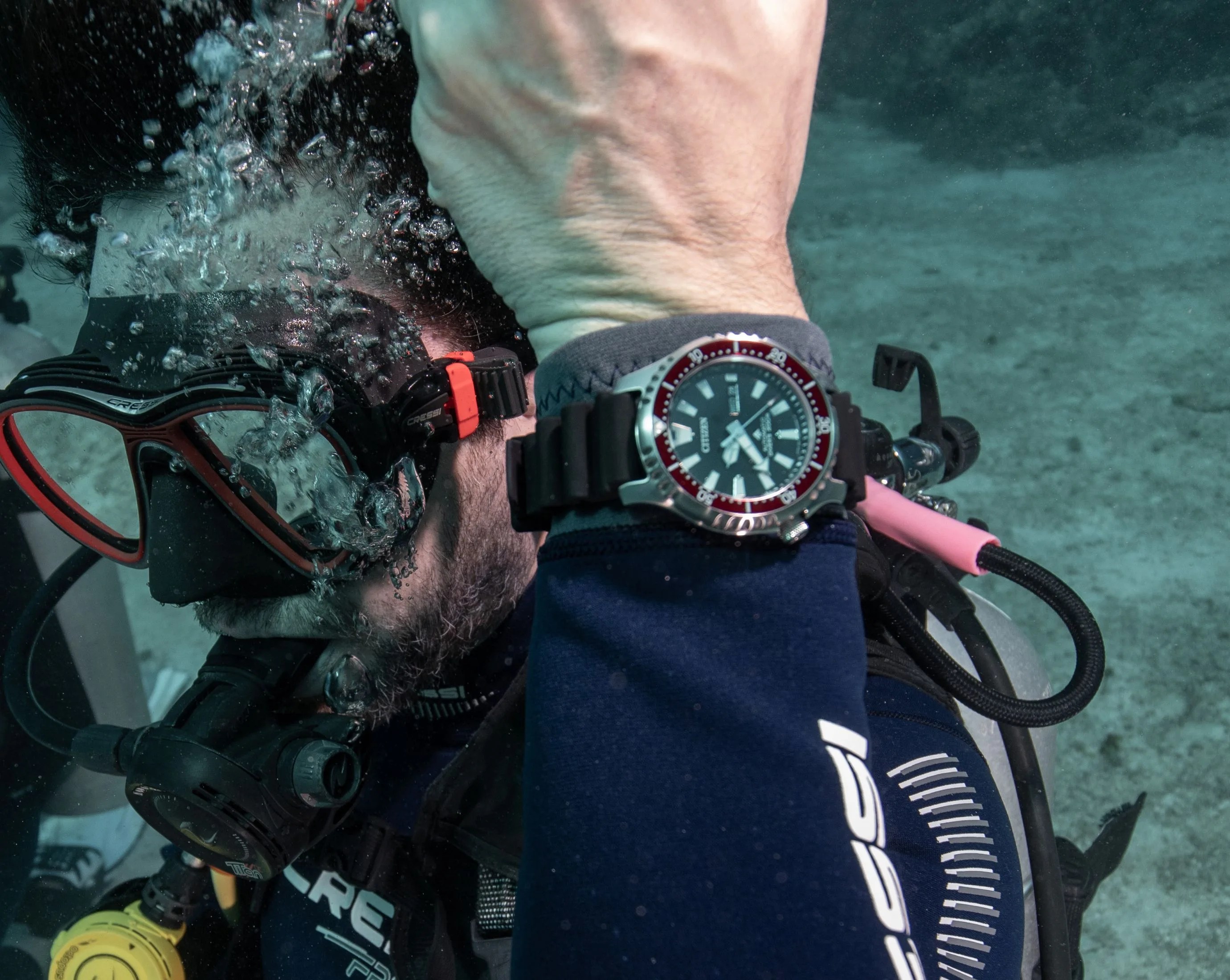 diver underwater wearing a dive watch