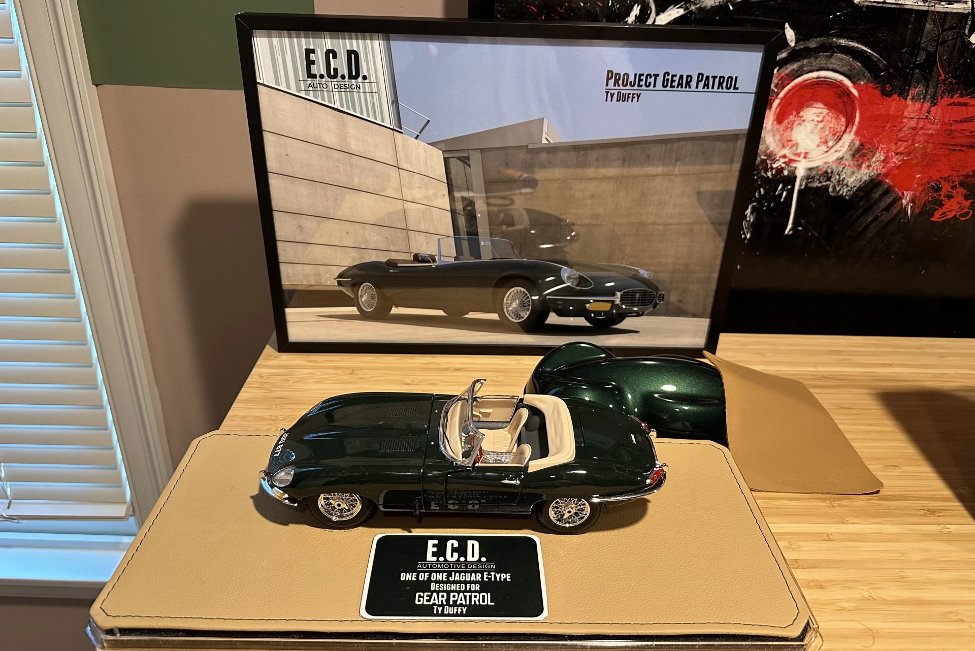 framed portrait and car model of the e type jaguar
