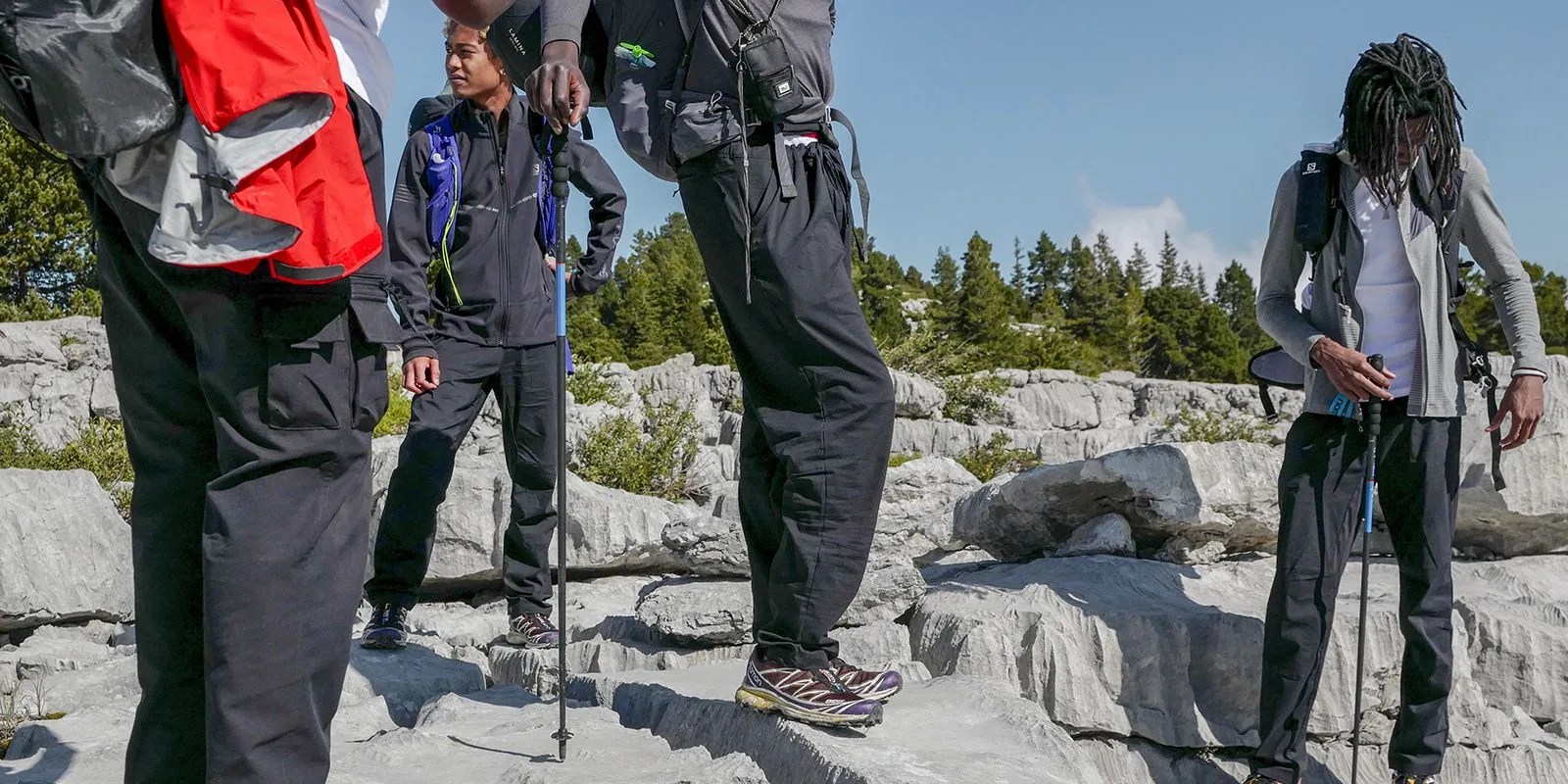 a group of people standing on rocks in hiking gear