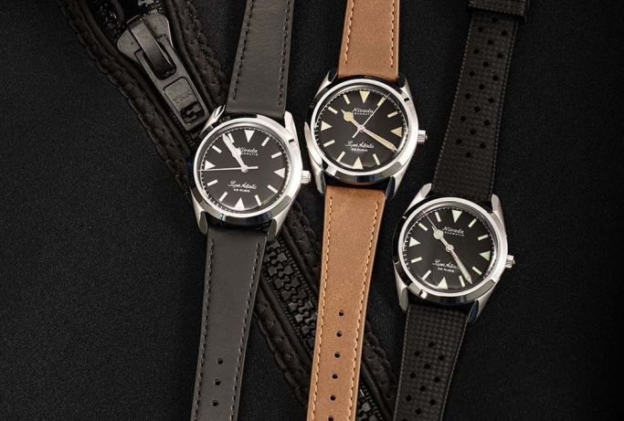 3 watches laying on a black jacket