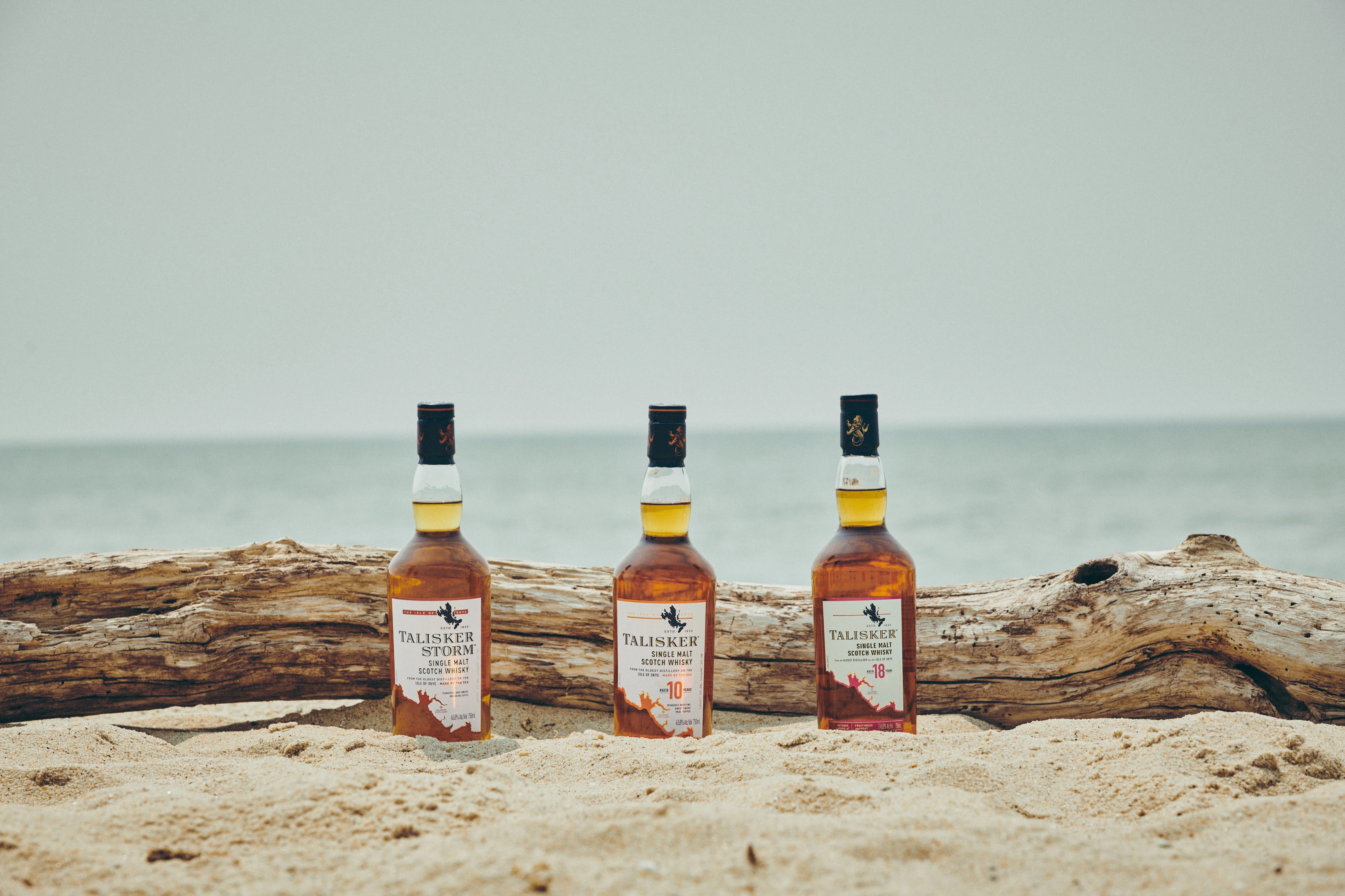 scotch whisky bottles on the beach