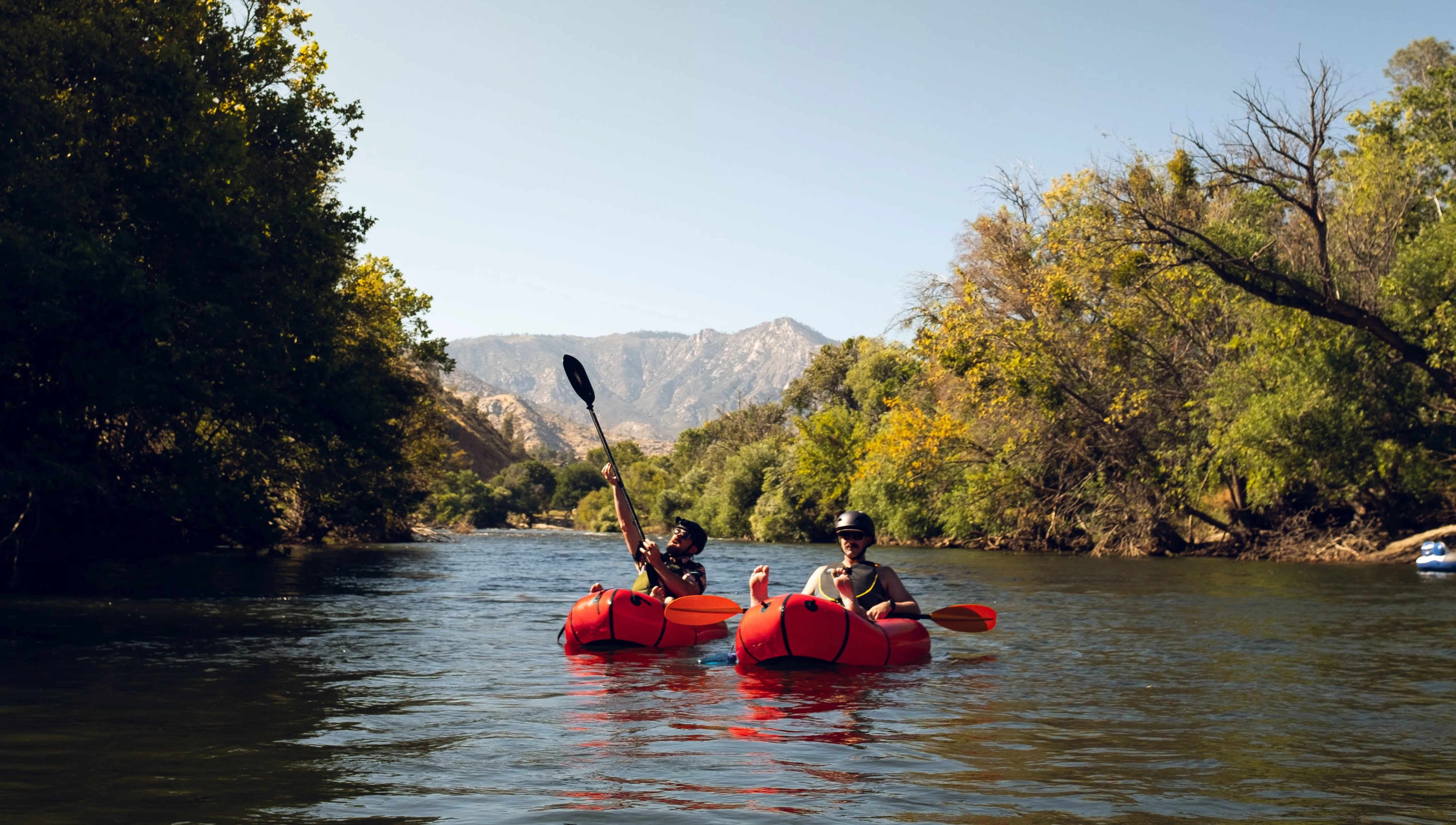 two men in paddle boats floating in the river
